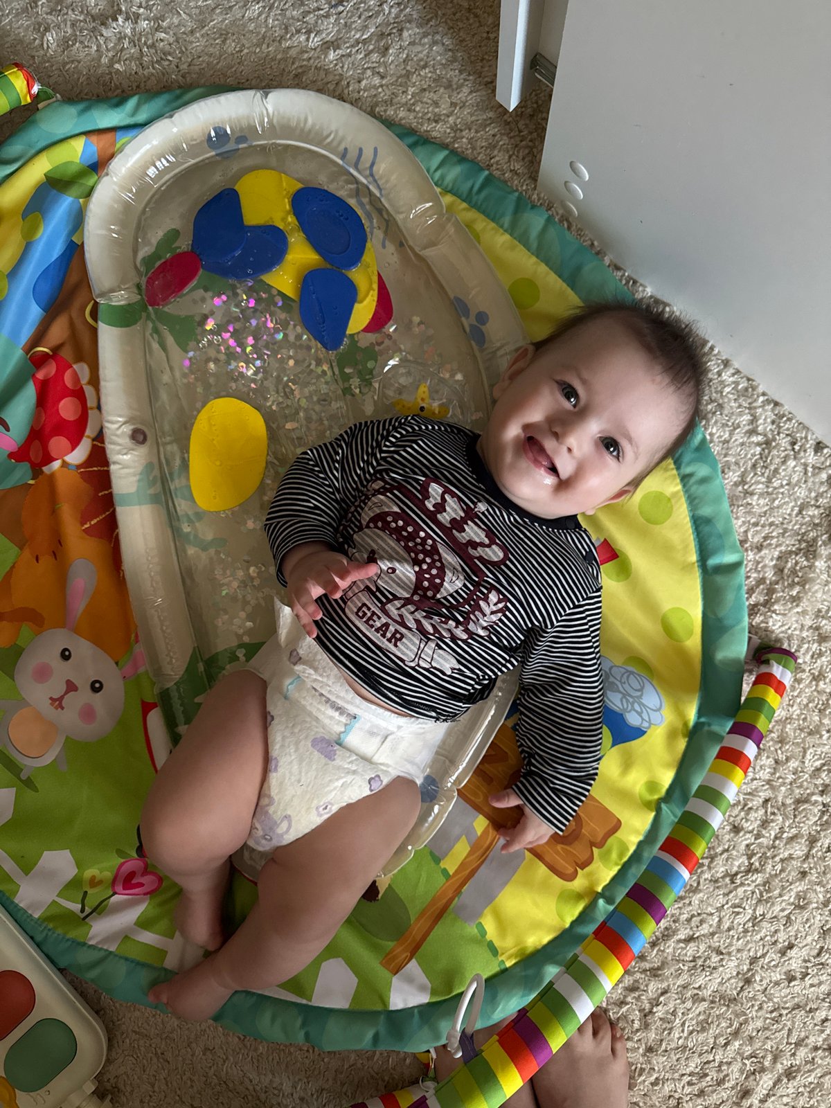 Baby plays on colorful mat in Kazan home