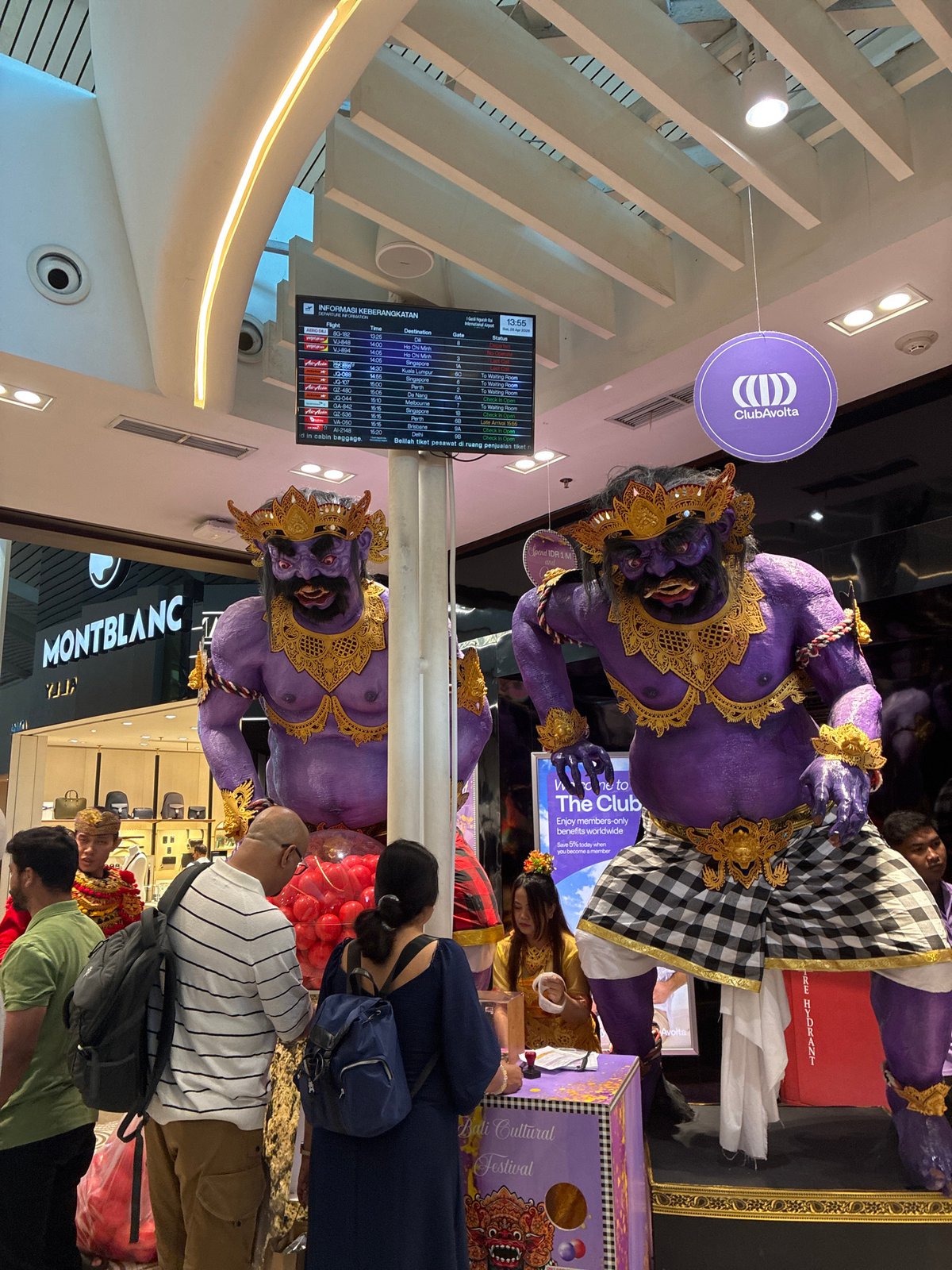 Kuta airport terminal observed with Balinese statues, duty-free shops