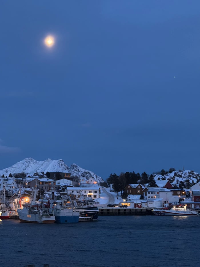Dusk captures snow-covered Ballstad coastal town in evening light