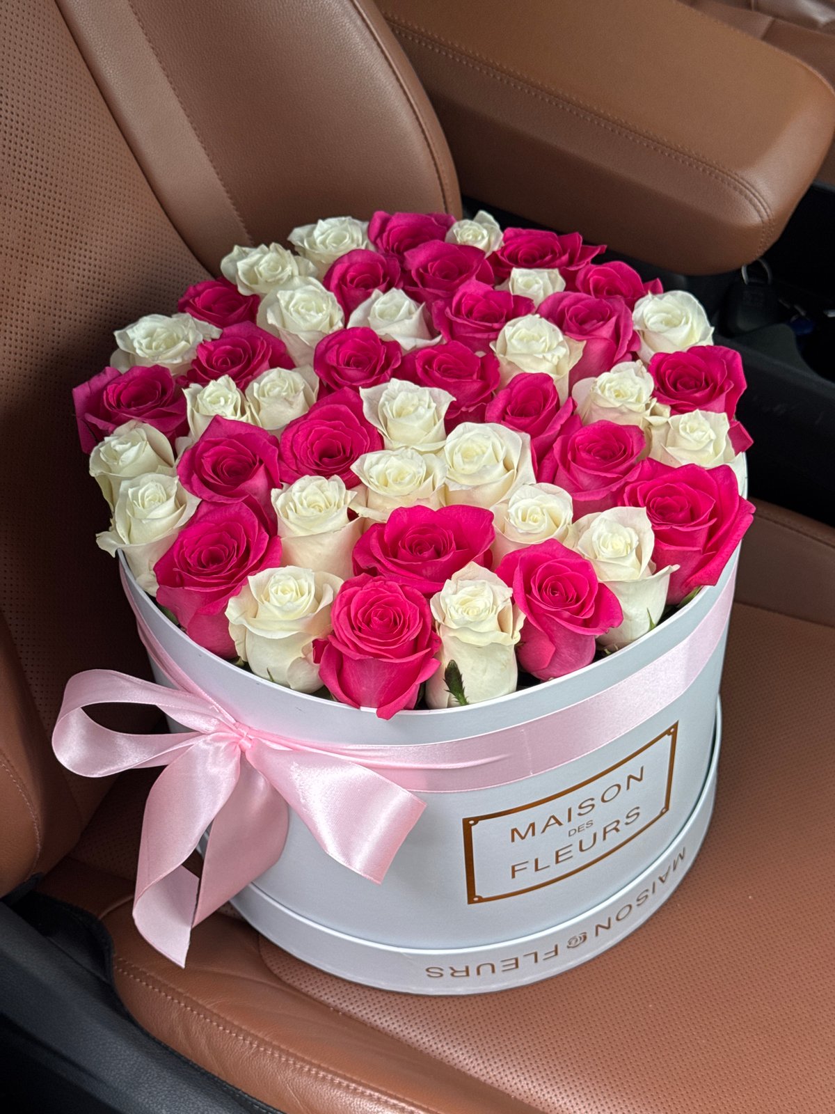 Branded rose hatbox on a car seat in Almaty