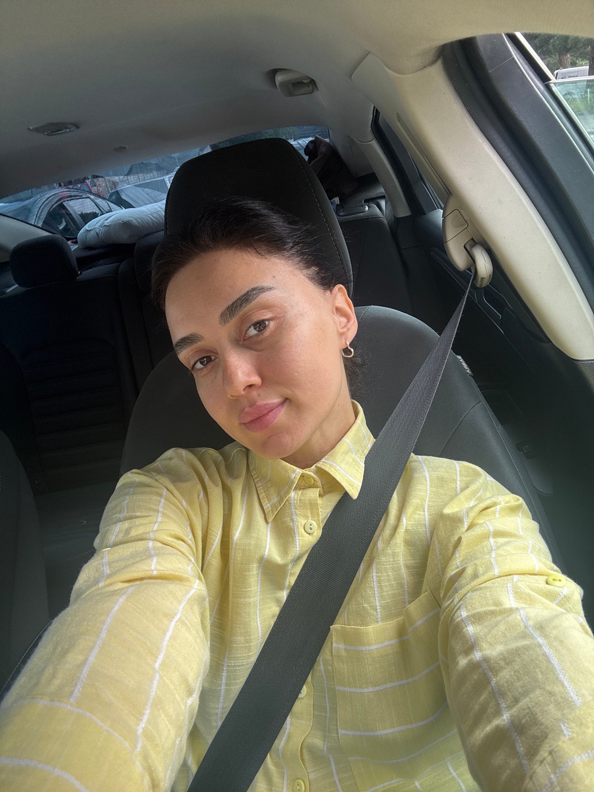 Woman takes morning selfies in car in Tbilisi