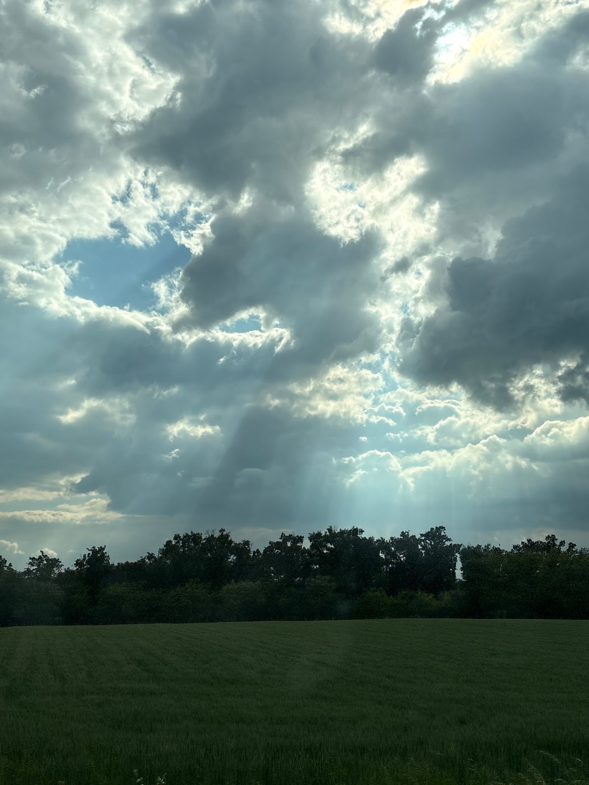 Dramatic sunbeams pierce clouds over Serbian countryside