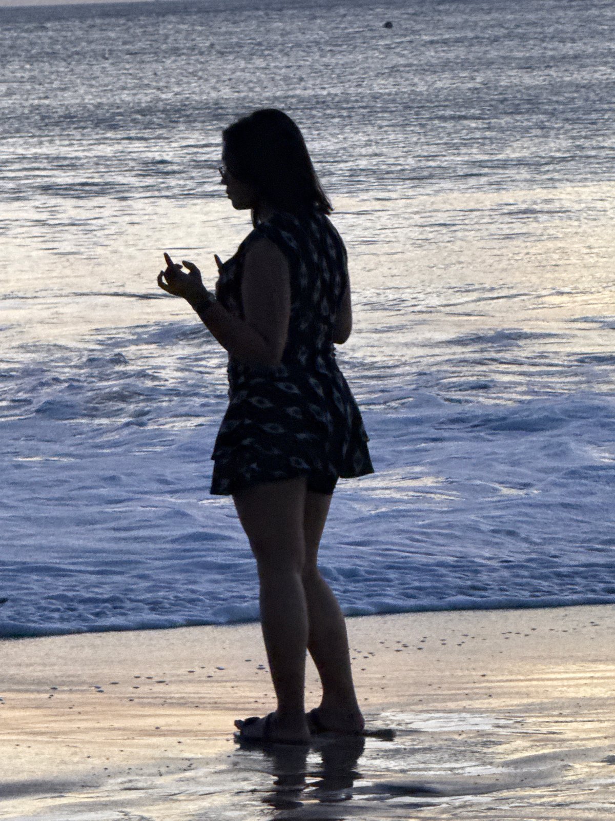 Kuta Beach shoreline activity during golden-hour overcast light