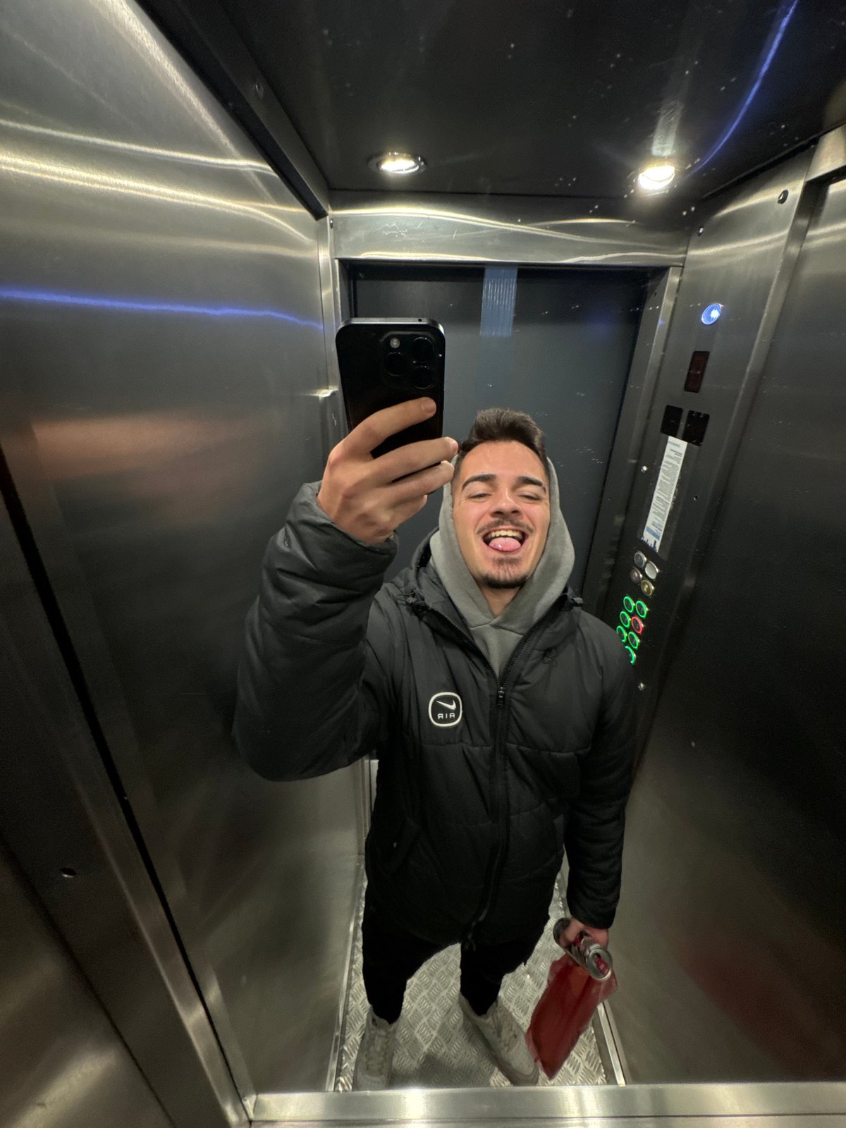 Young man takes selfies in Sofia elevator wearing puffer jacket