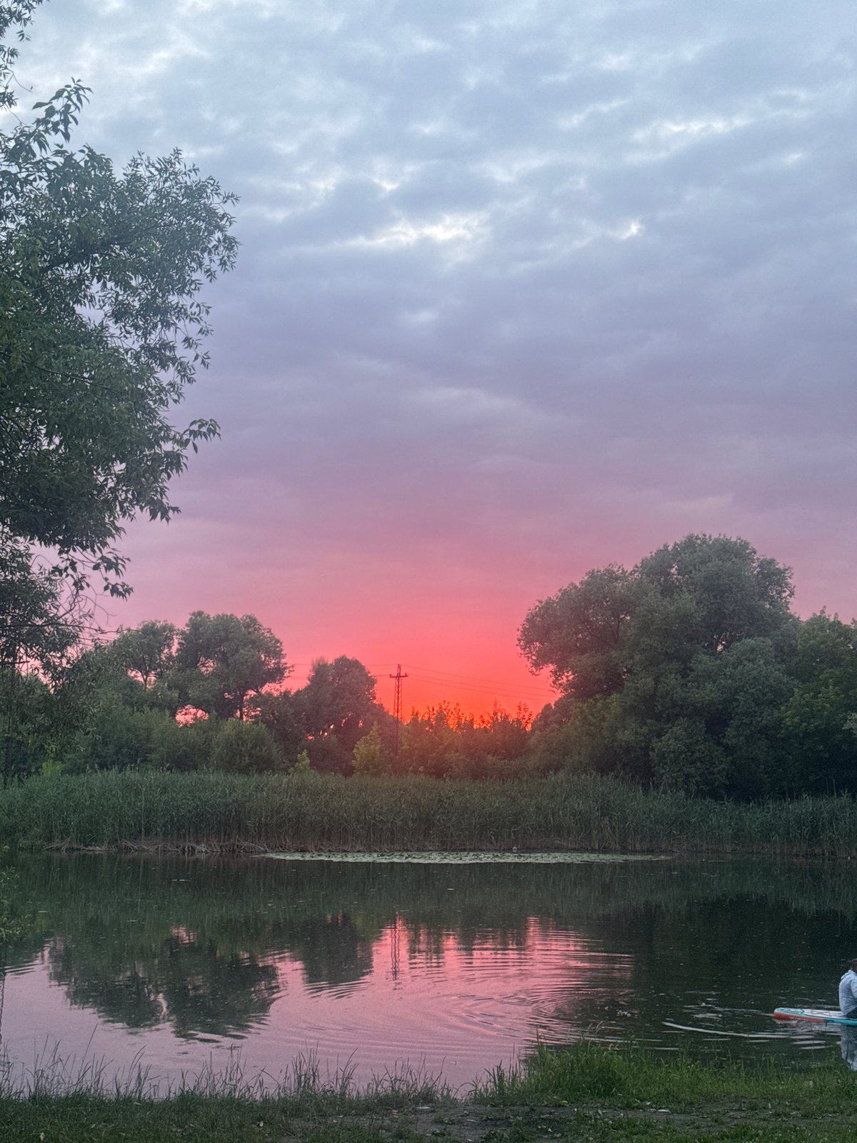 Vivid summer sunset reflects over calm Russian waterway