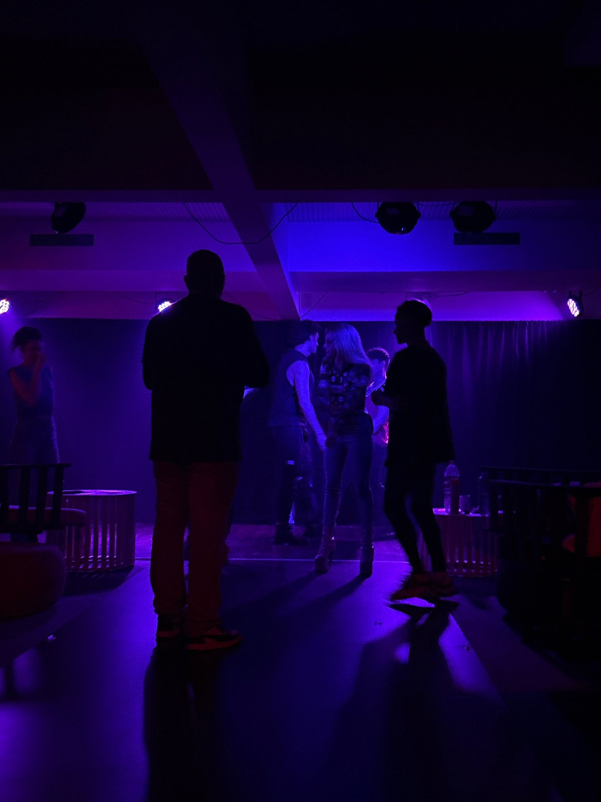 Late-night Buenos Aires event with dramatic stage lighting and a standout white gown