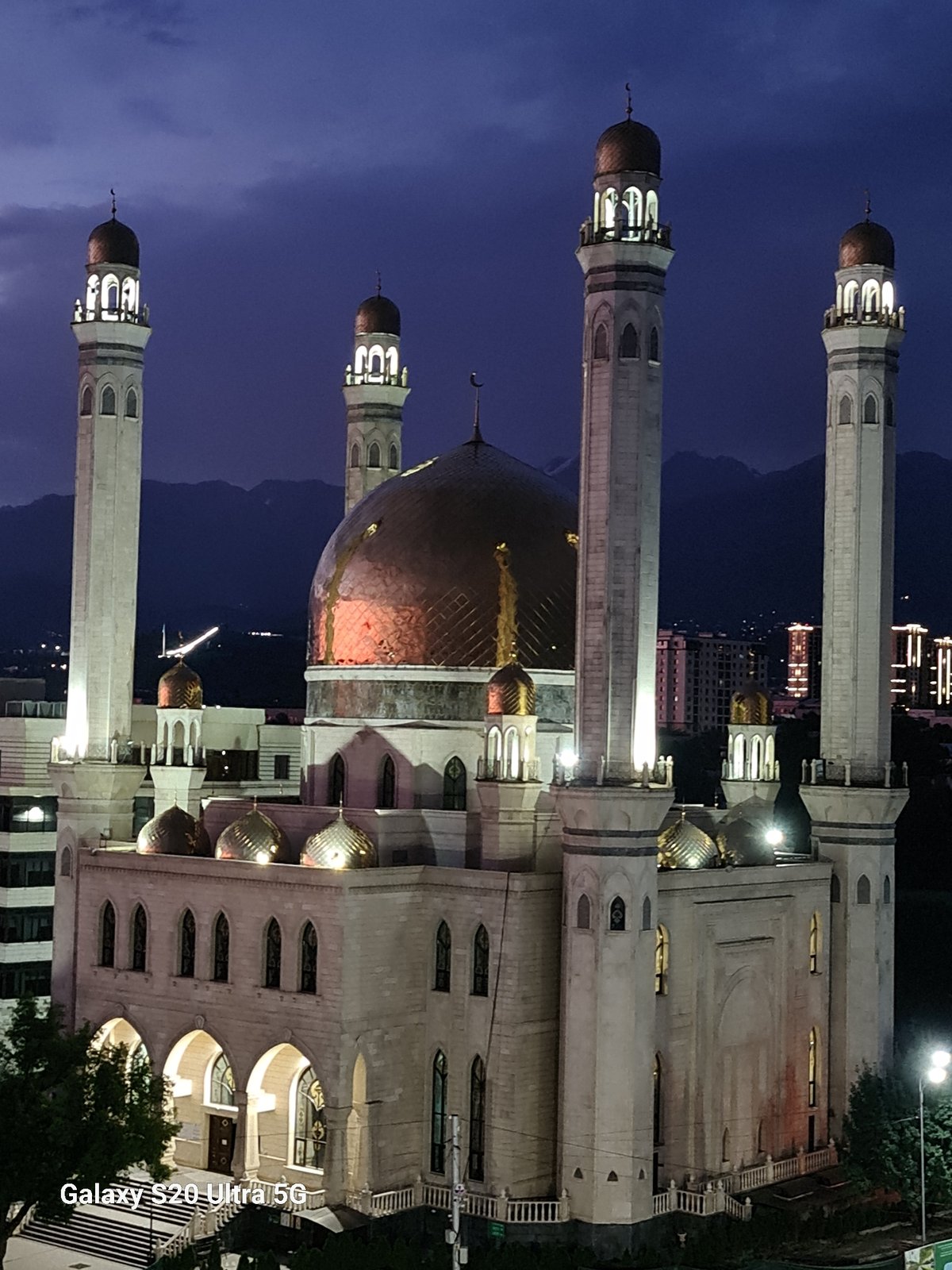 Almaty's Central Mosque glows at dusk under a vivid twilight sky