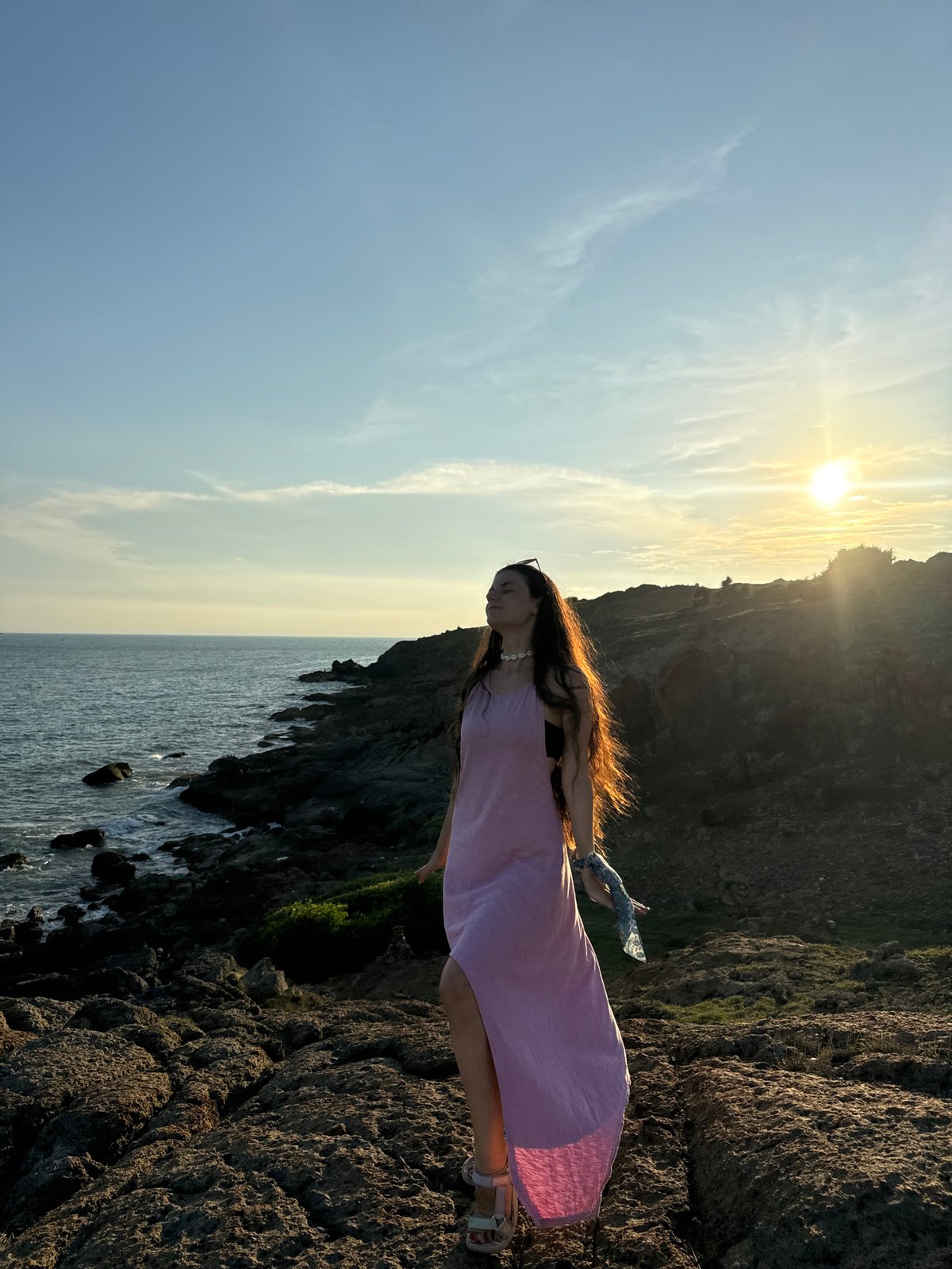 Women pose for photos on Mui Ne coastline at sunset