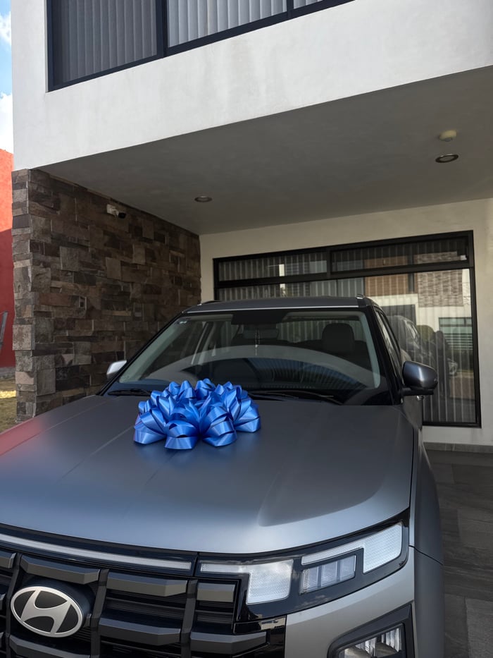 Woman poses with bow-decorated SUV in Puebla driveway