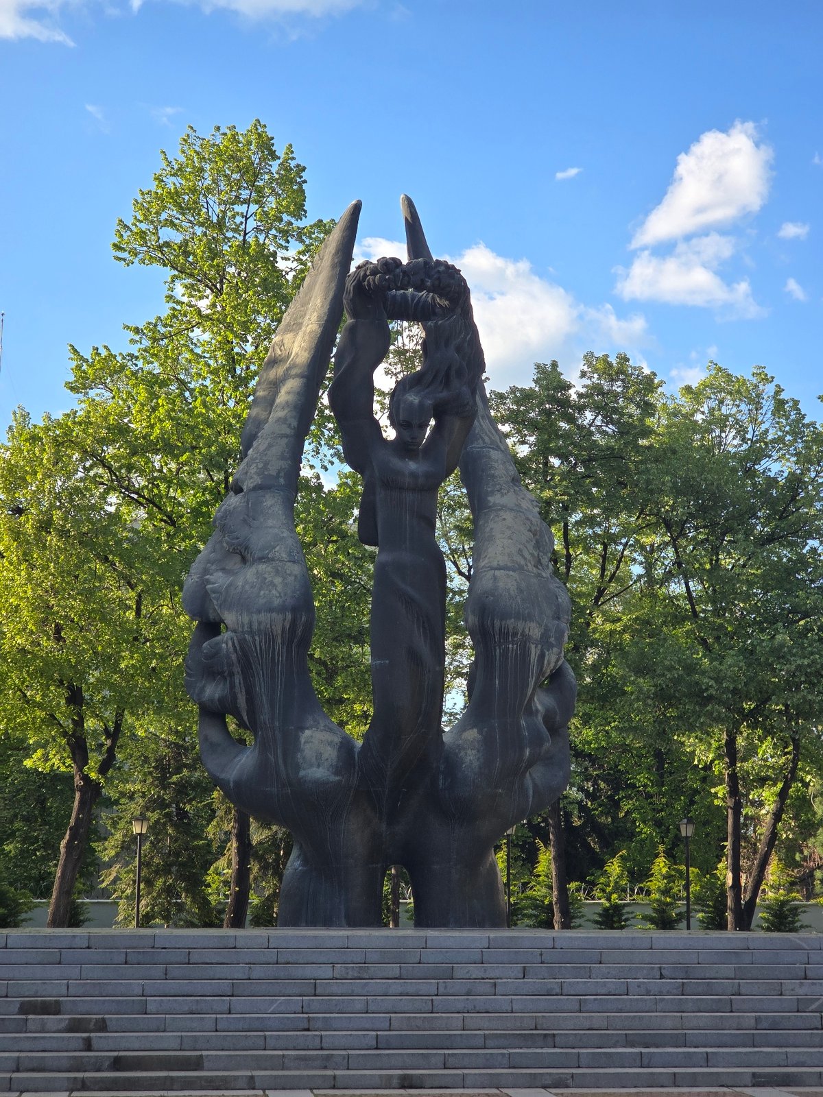 Urban park moments: sculpture, flowers, cat on bench documented