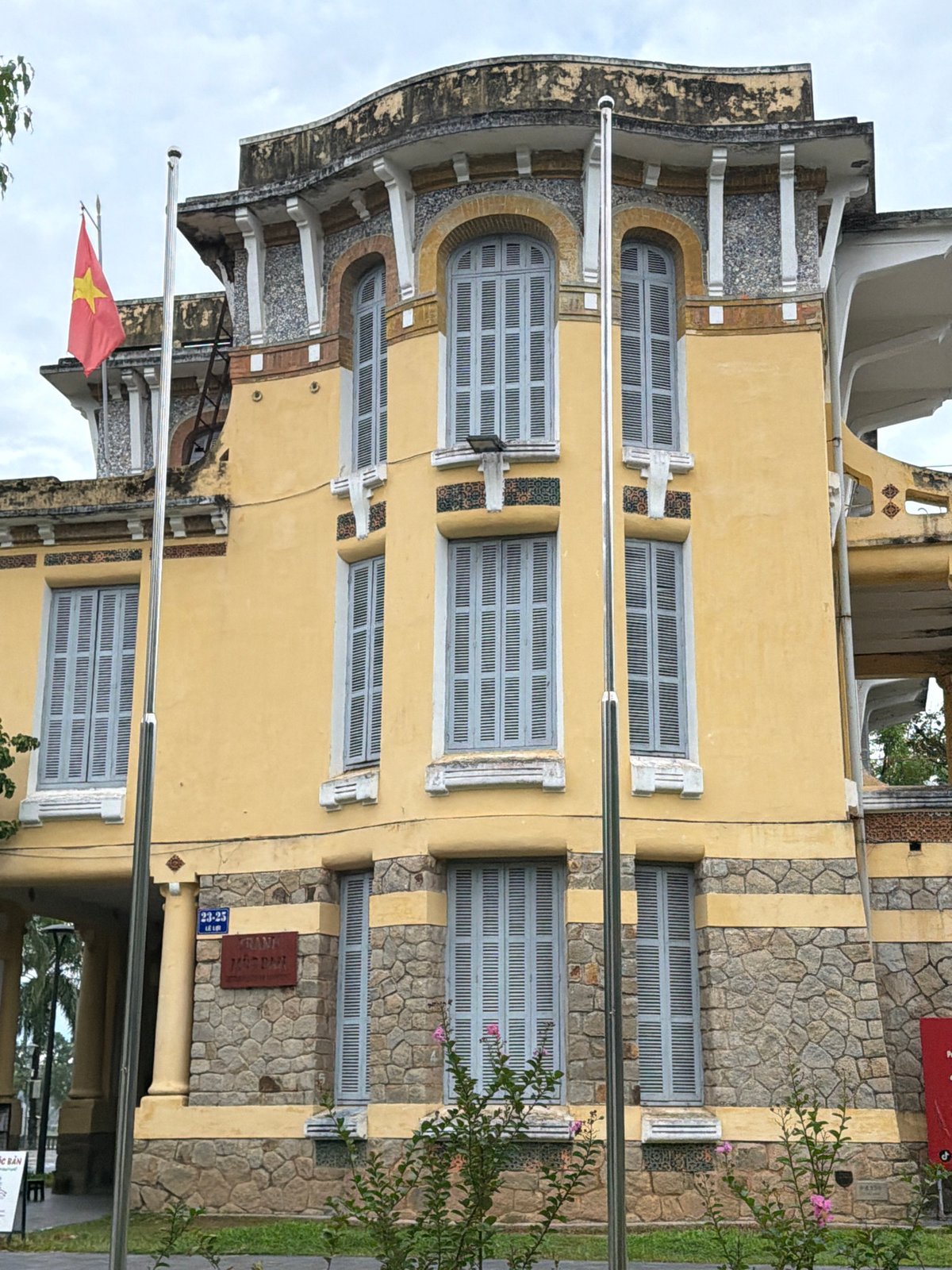 Yellow colonial building with Vietnamese flag, Thuận Hóa Ward