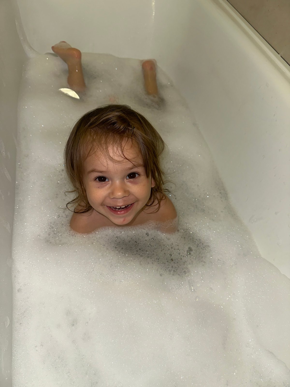Toddler enjoys bubble bath with starfish toy in Kharnavy