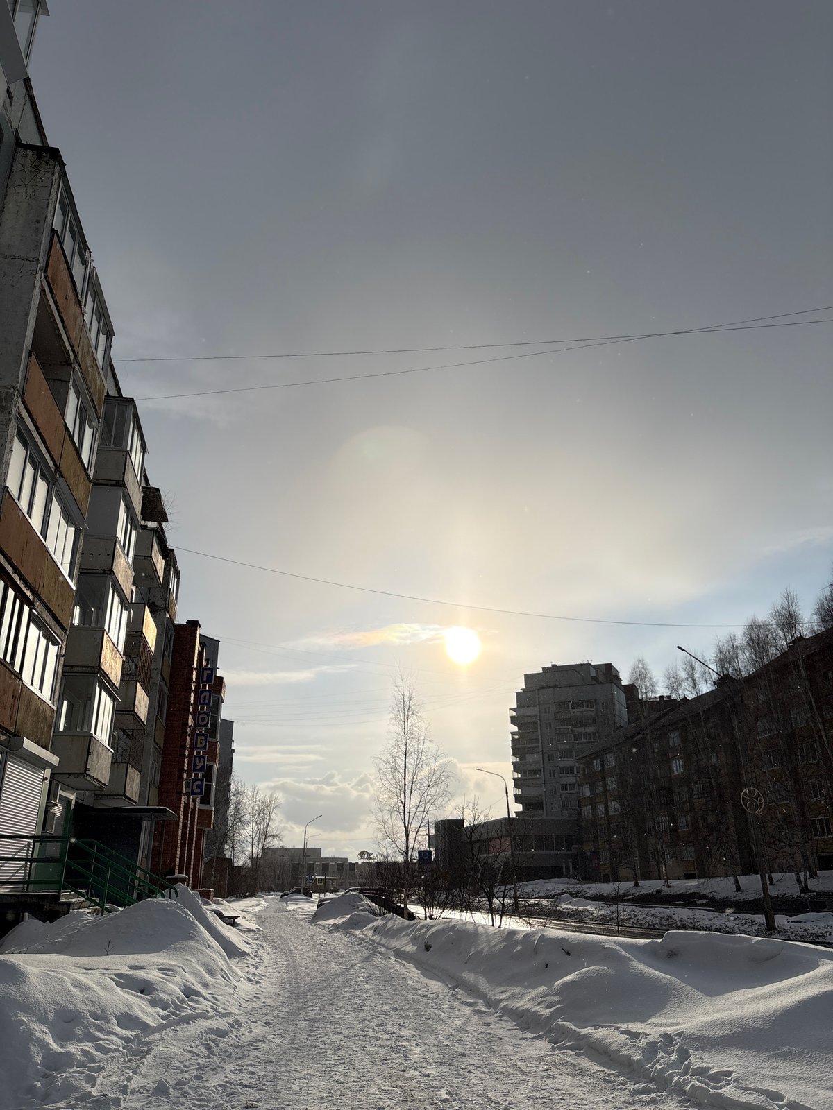 Heavy snow blankets residential Ust-Ilimsk under hazy sun