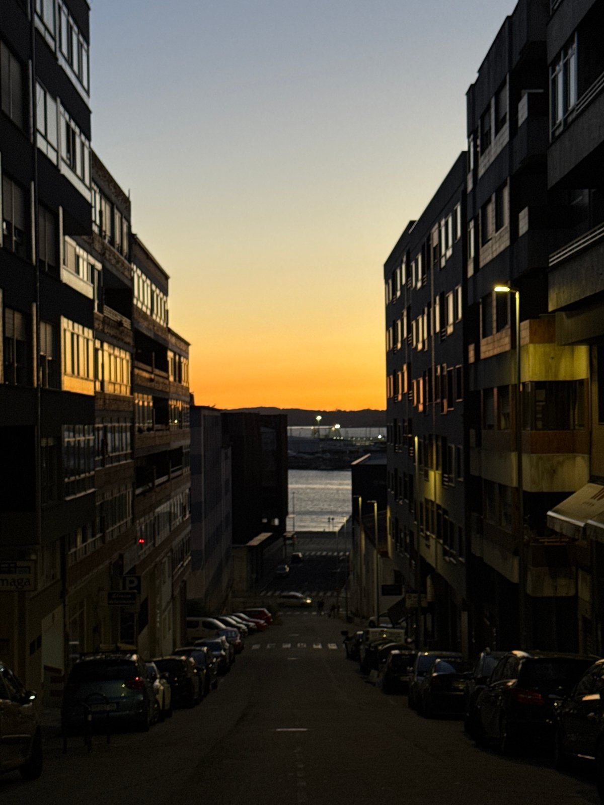 Vigo street at dusk, building windows glowing with sunset light