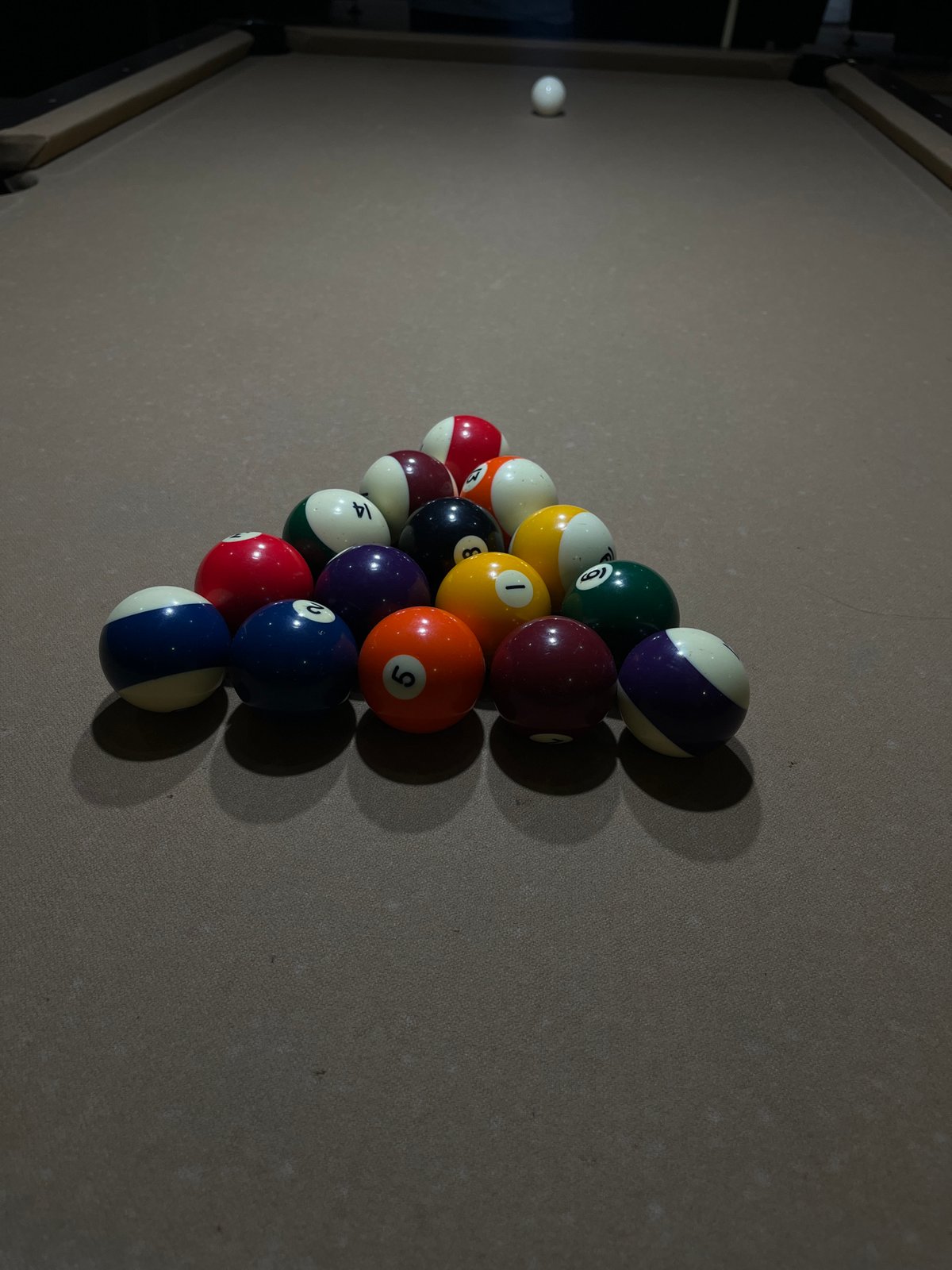 Pool balls racked on billiard table captured indoors