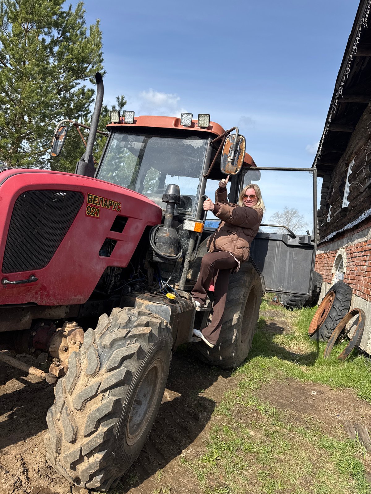 Woman poses with farm equipment in rural Russia