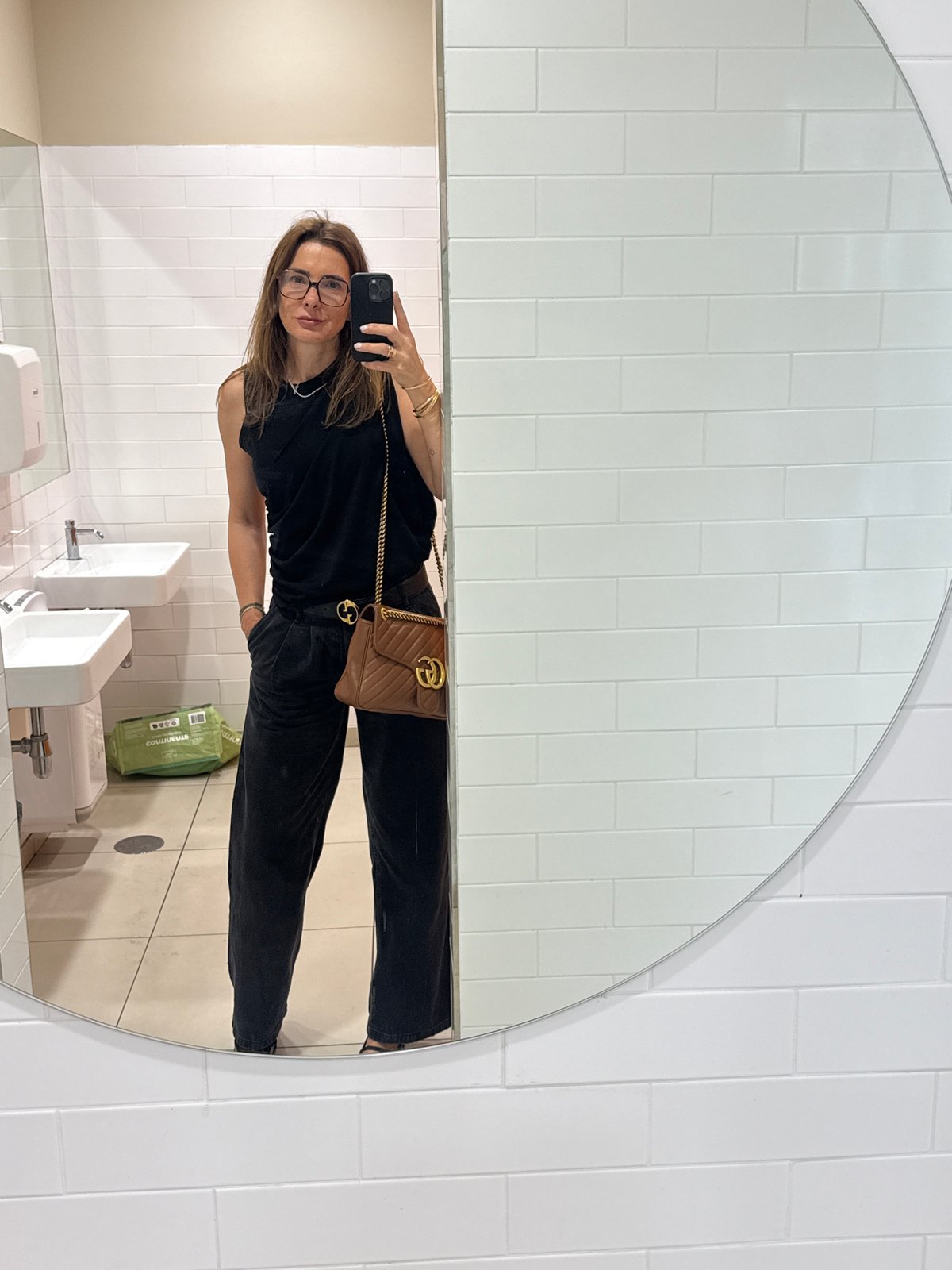 Woman takes mirror selfie in Vila Nova de Gaia restroom