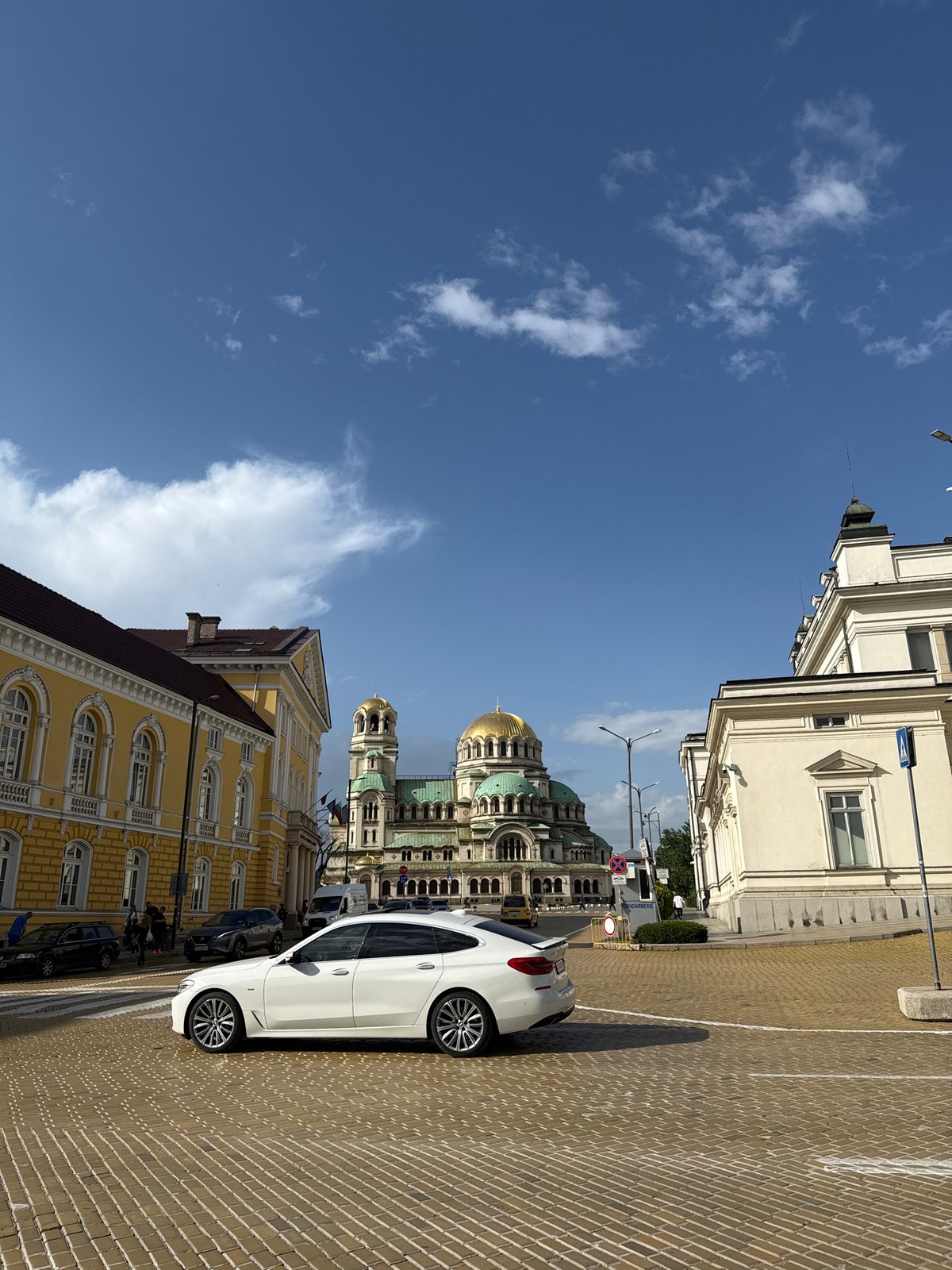 White car parked on cobblestone street in Sofia