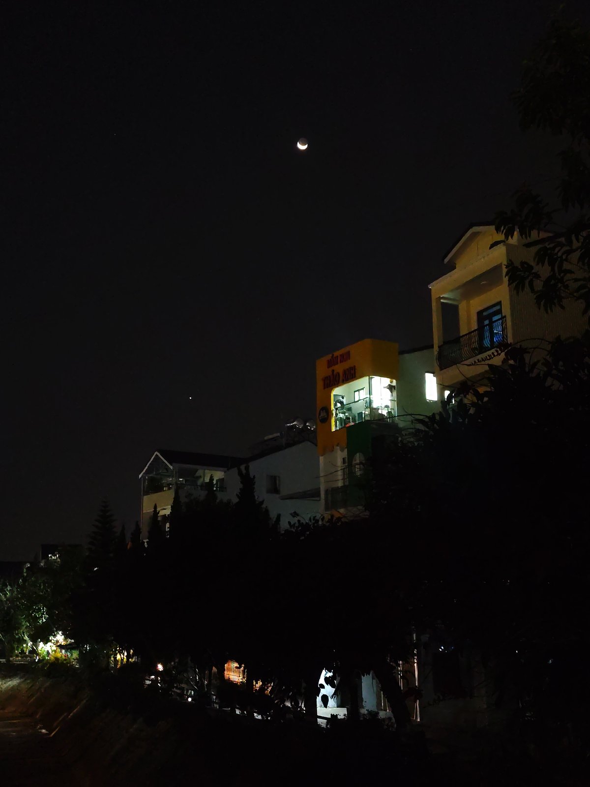 Crescent moon illuminates quiet Da Lat streets during evening hours