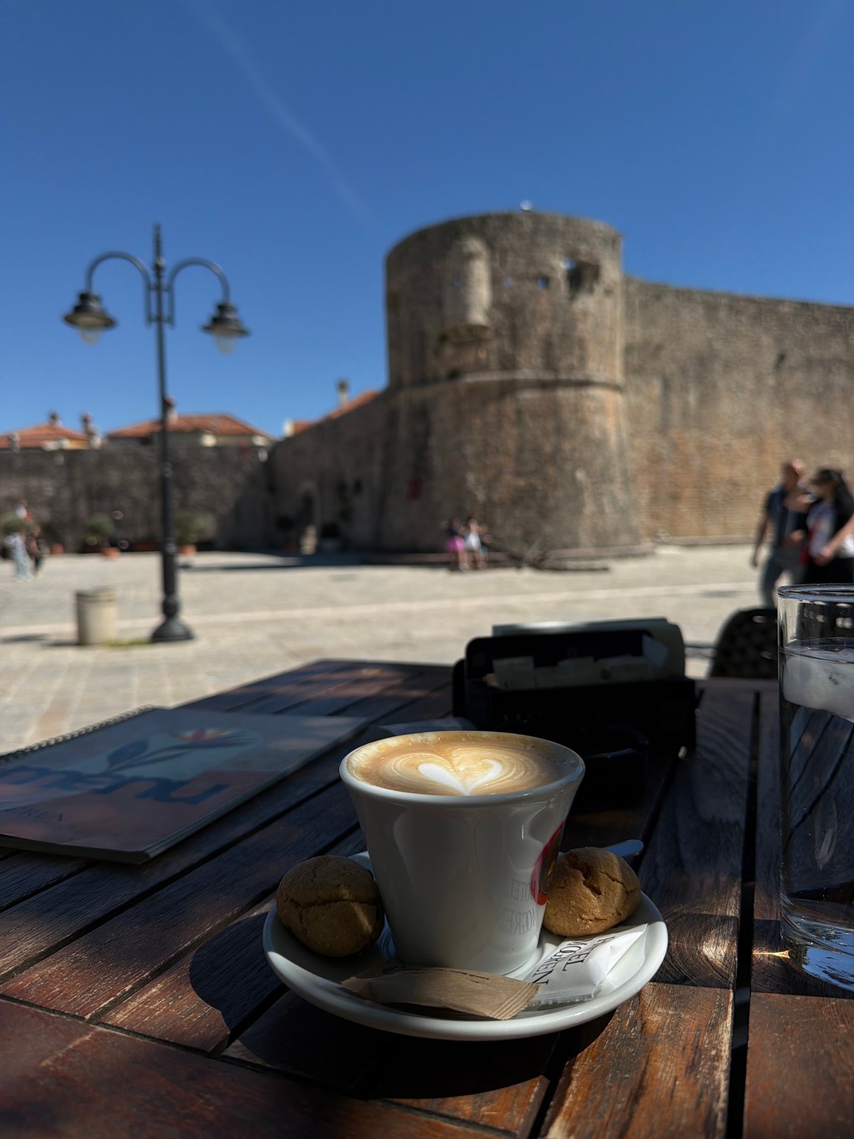 Coffee break documented at historic Budva cafe near ancient walls