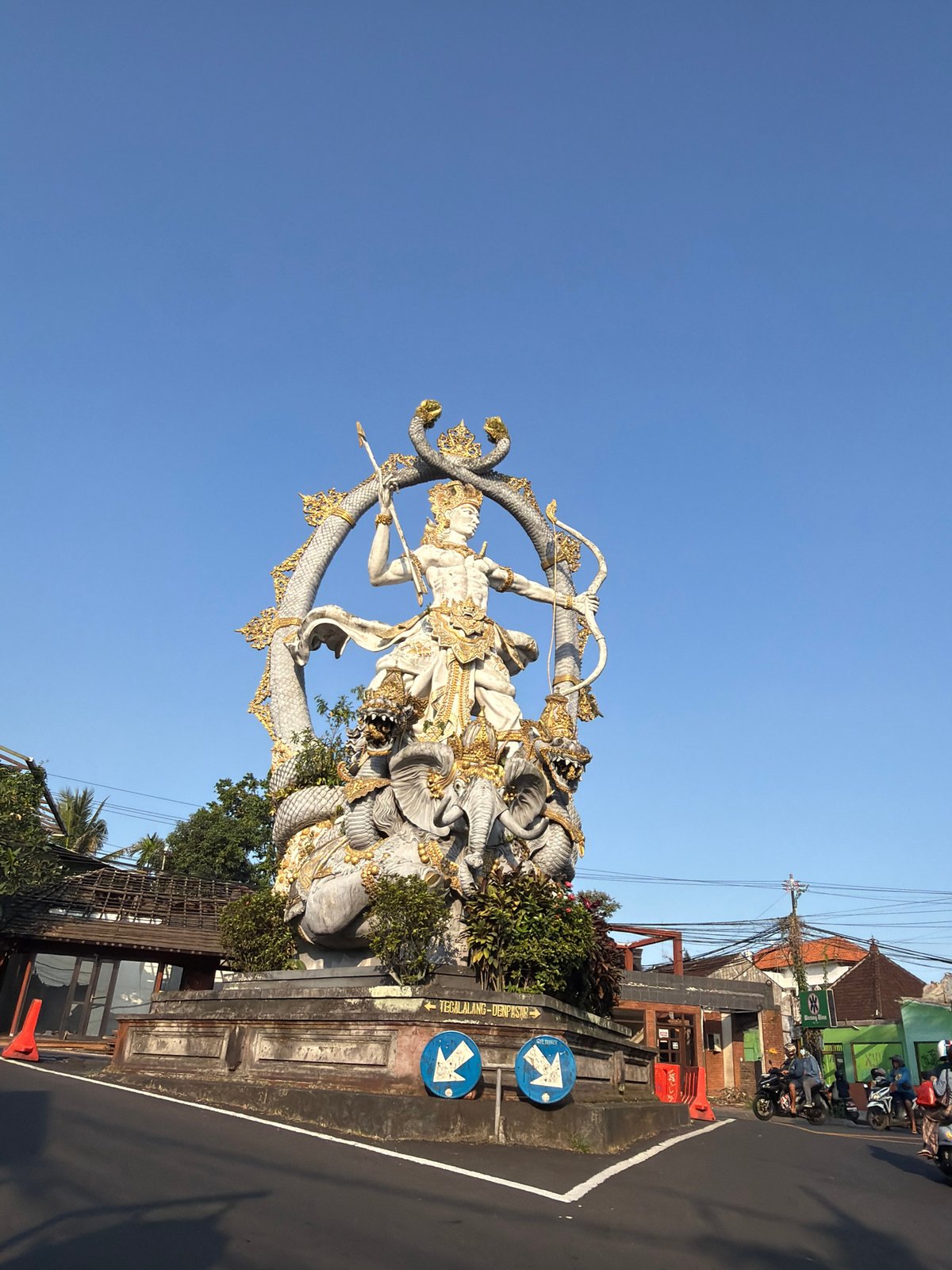 Statues, palms, and a Grab scooter in sunny Ubud