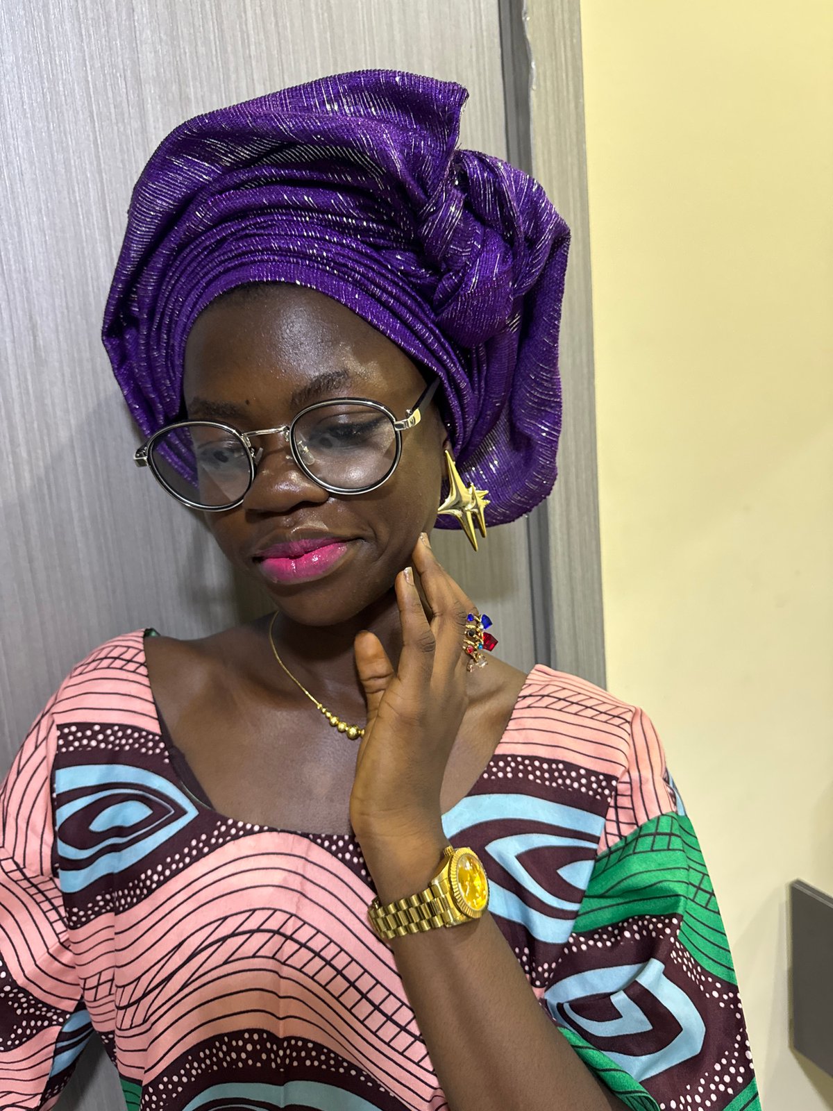 Woman in purple headwrap takes selfies, applies makeup in Nigeria
