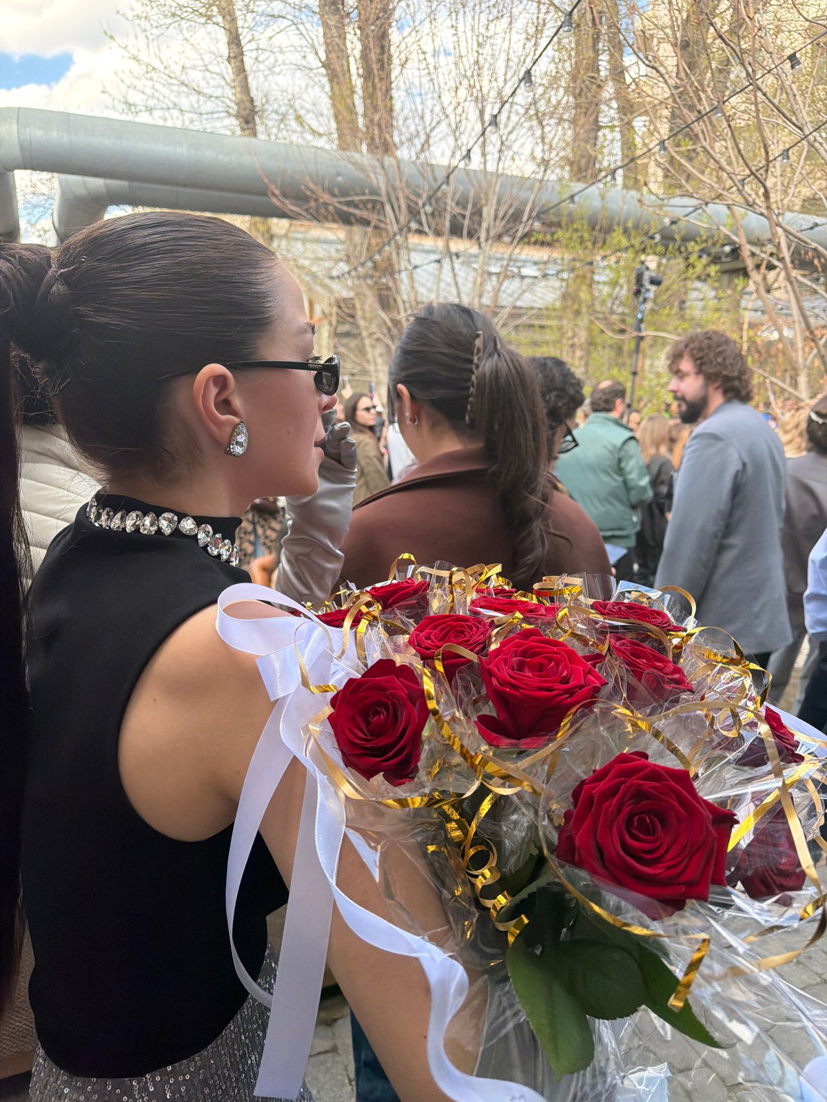 Woman with diamond jewelry holds rose bouquet in Moscow