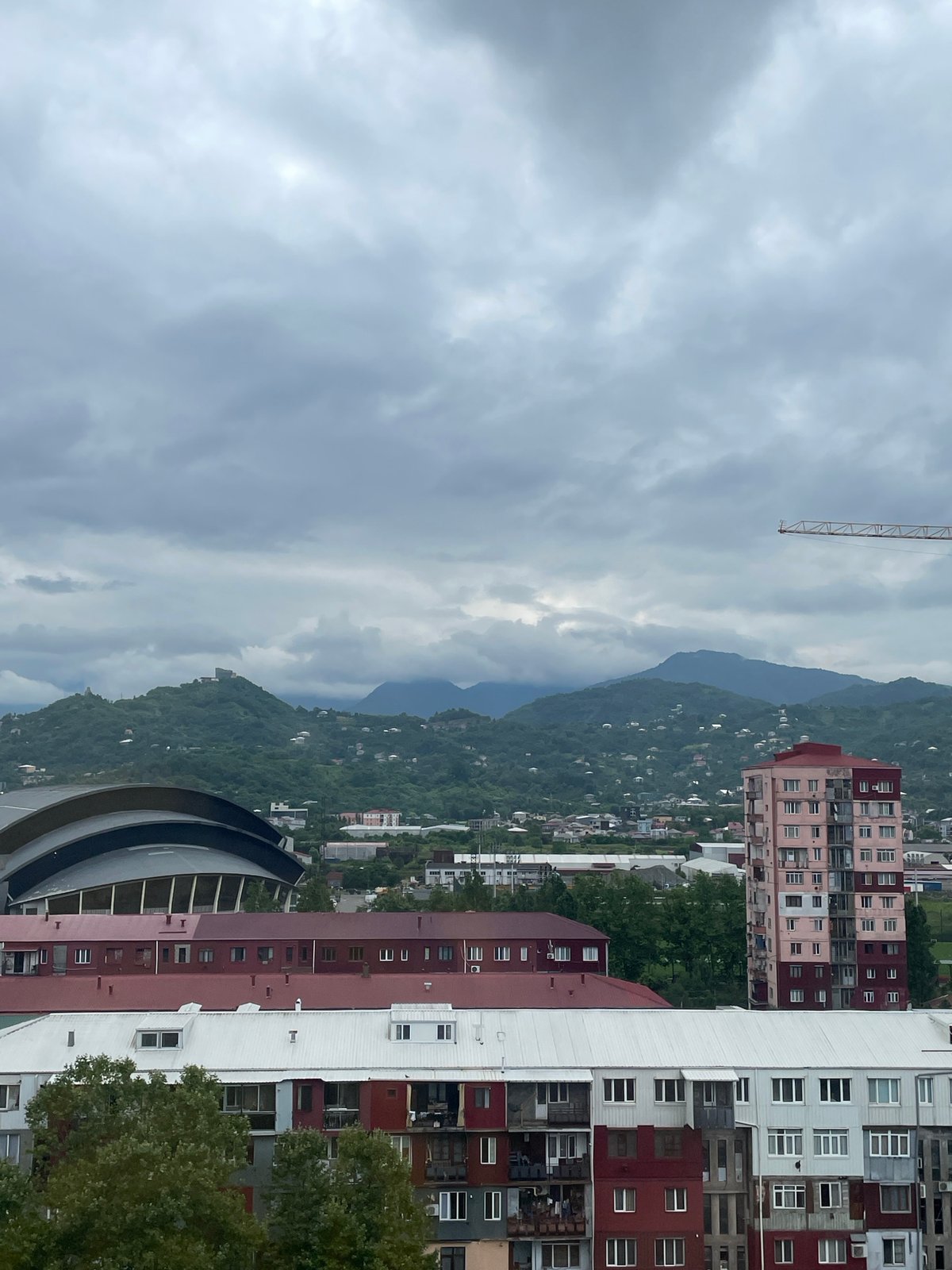 Batumi apartment blocks under overcast skies, mountains behind