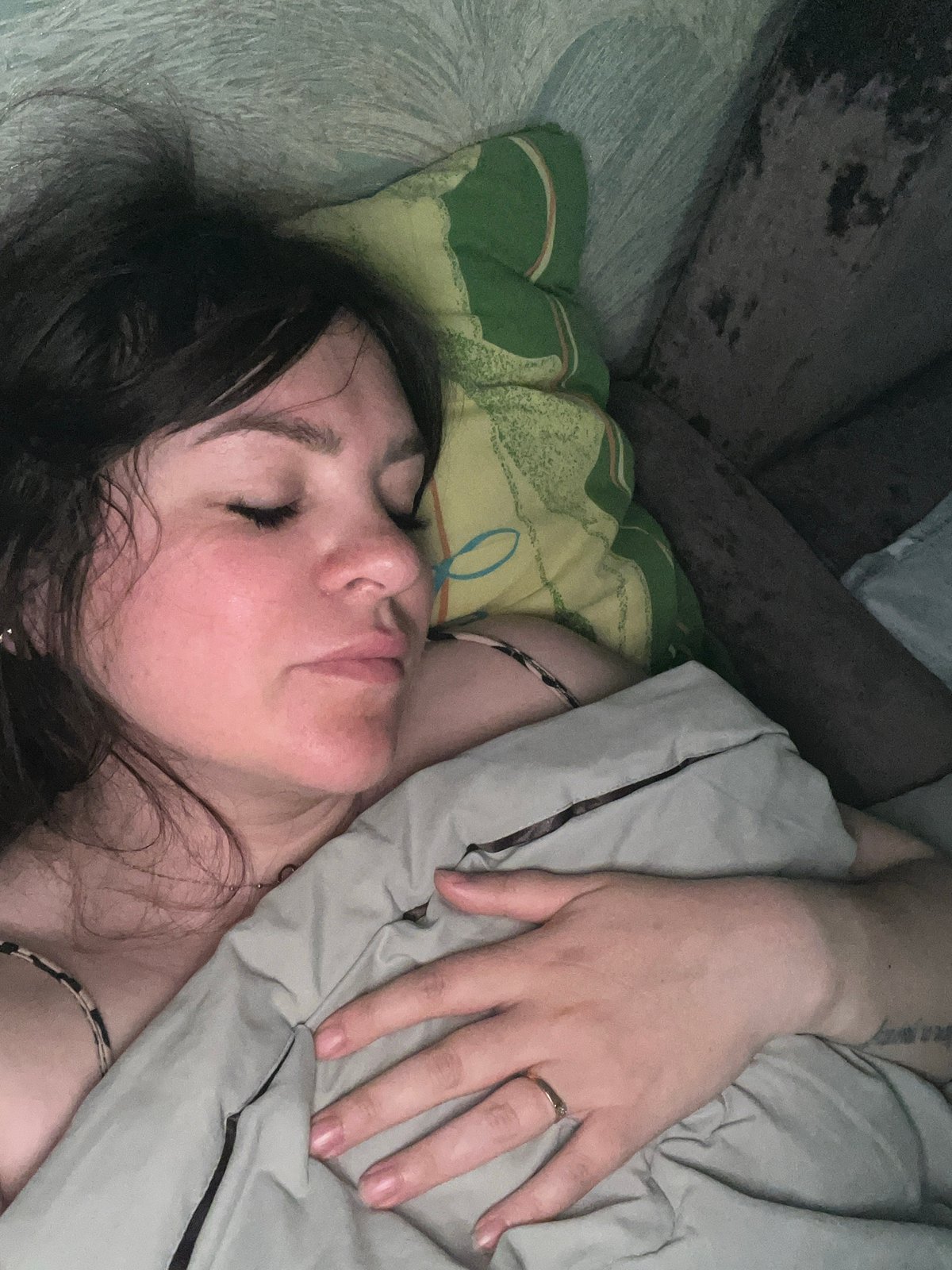 Woman rests in bedroom while children's TV plays, Noviy Russia