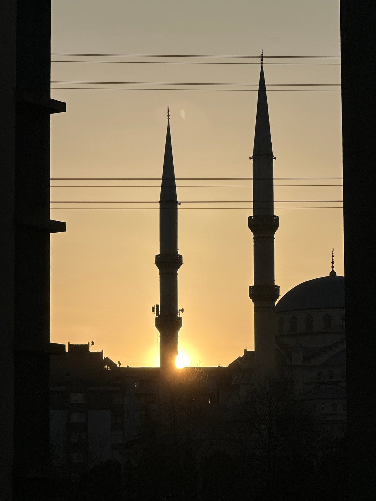 Sunrise silhouettes mosque minarets in Esenyurt, Turkey