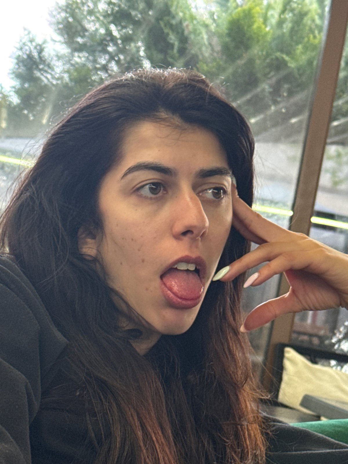 Woman makes playful tongue gesture in Kazanlak, Bulgaria