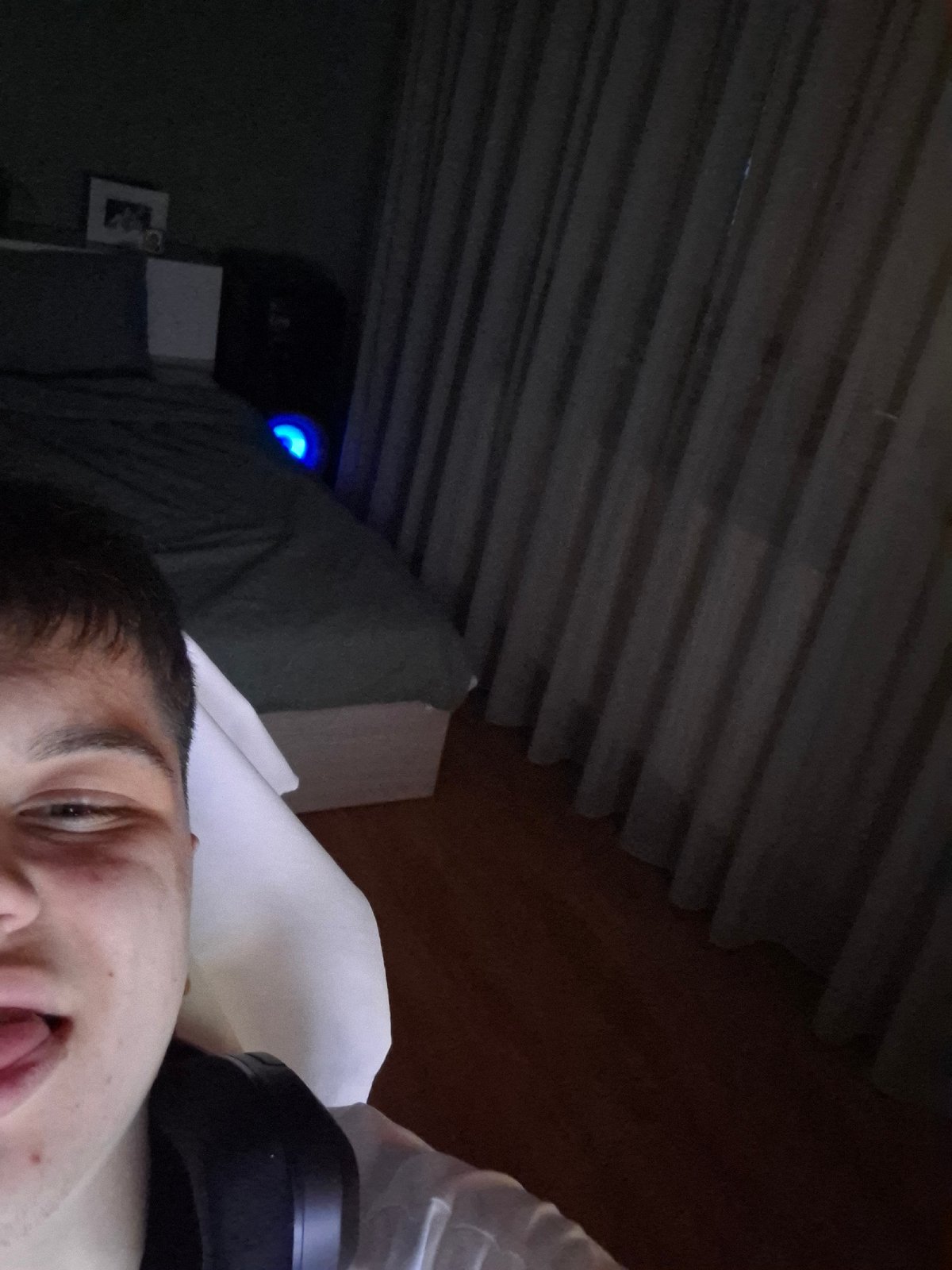 Person resting in bed with headphones in Veliki Preslav