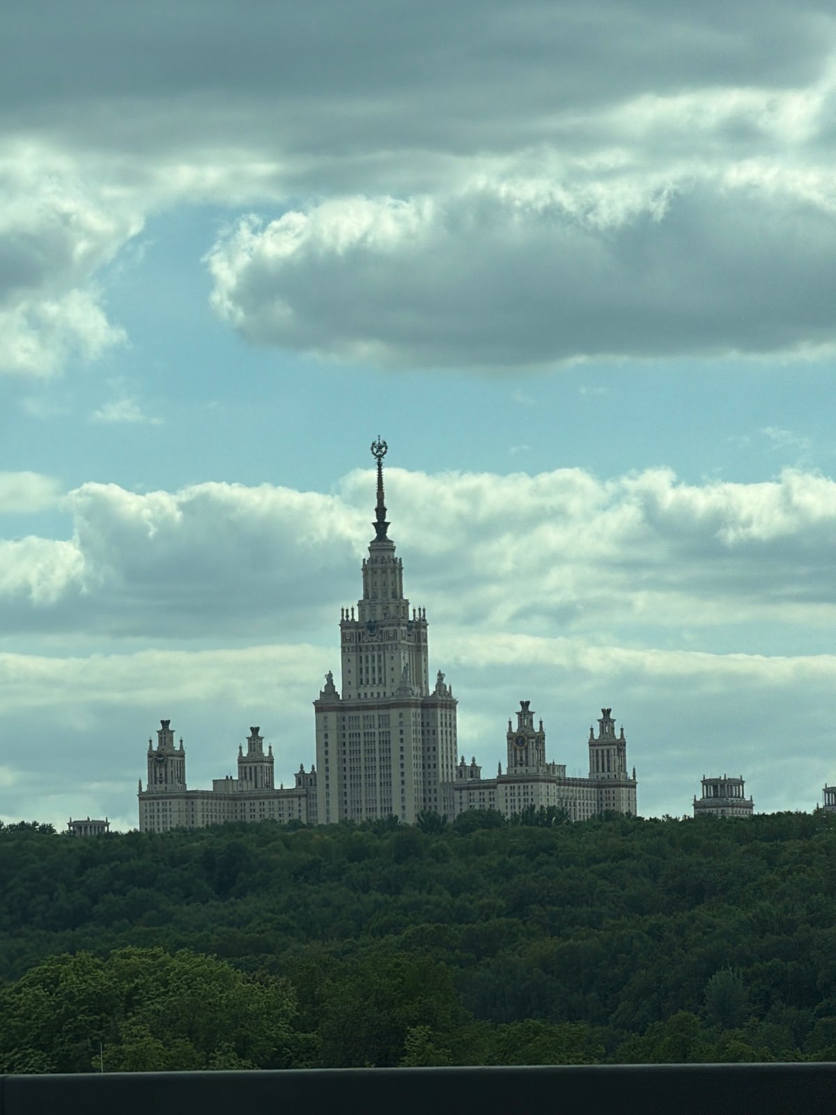 Moscow State University building photographed amid trees and clouds
