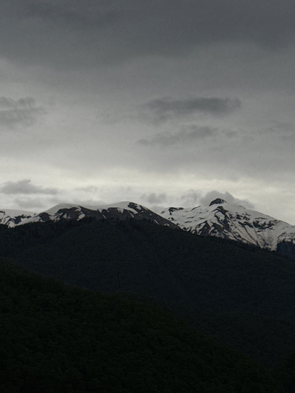 Snow-capped mountains observed under cloudy skies in Krasnaya Polyana