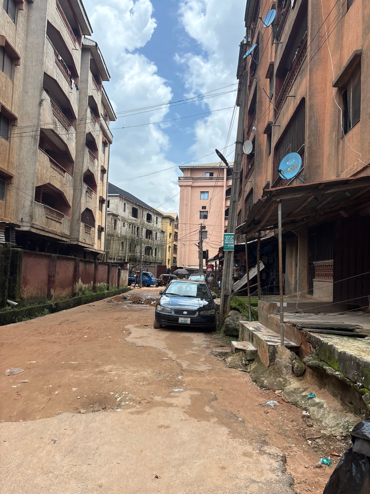 Everyday street life along a potholed Onitsha neighborhood.
