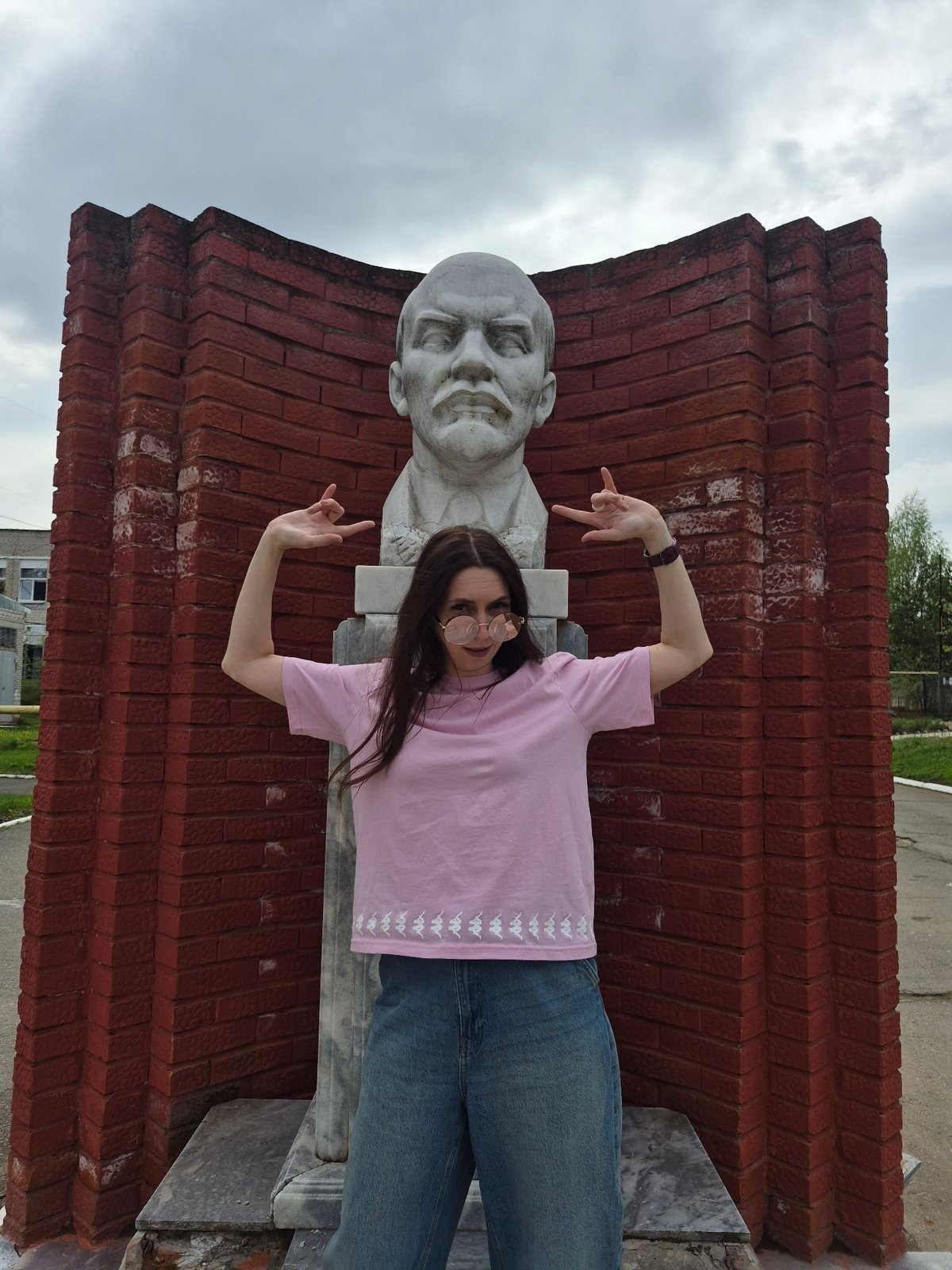 Woman in dandelion sunglasses tours urban area near Lenin monument