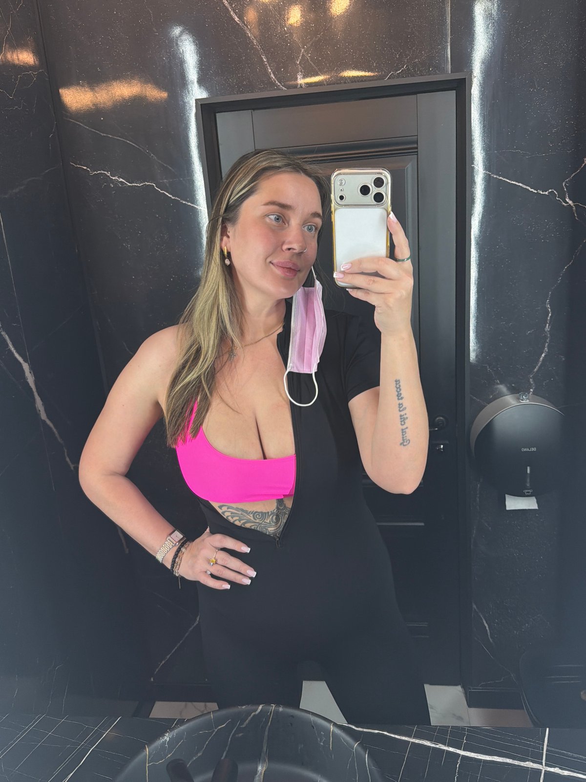 Woman takes selfie in Moscow bathroom wearing athletic attire