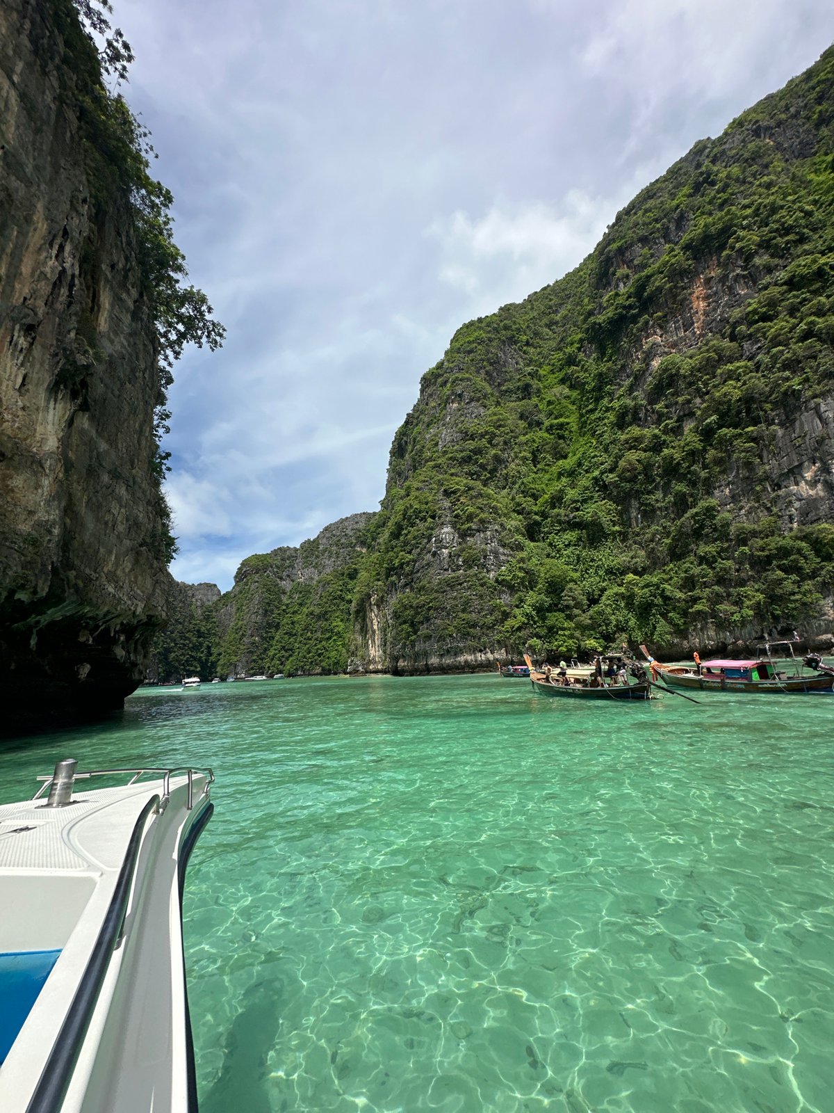 Longtail boats navigate turquoise bays among Krabi's limestone cliffs