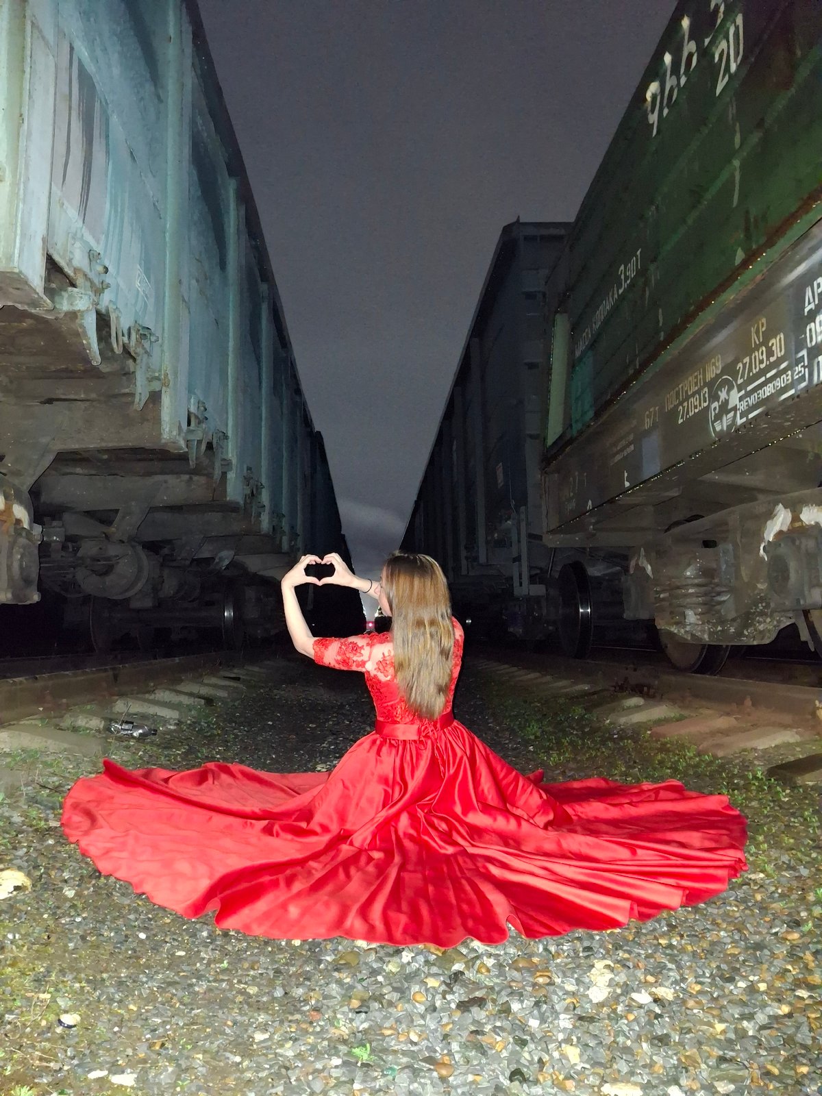Woman photographs weathered train cars in urban setting