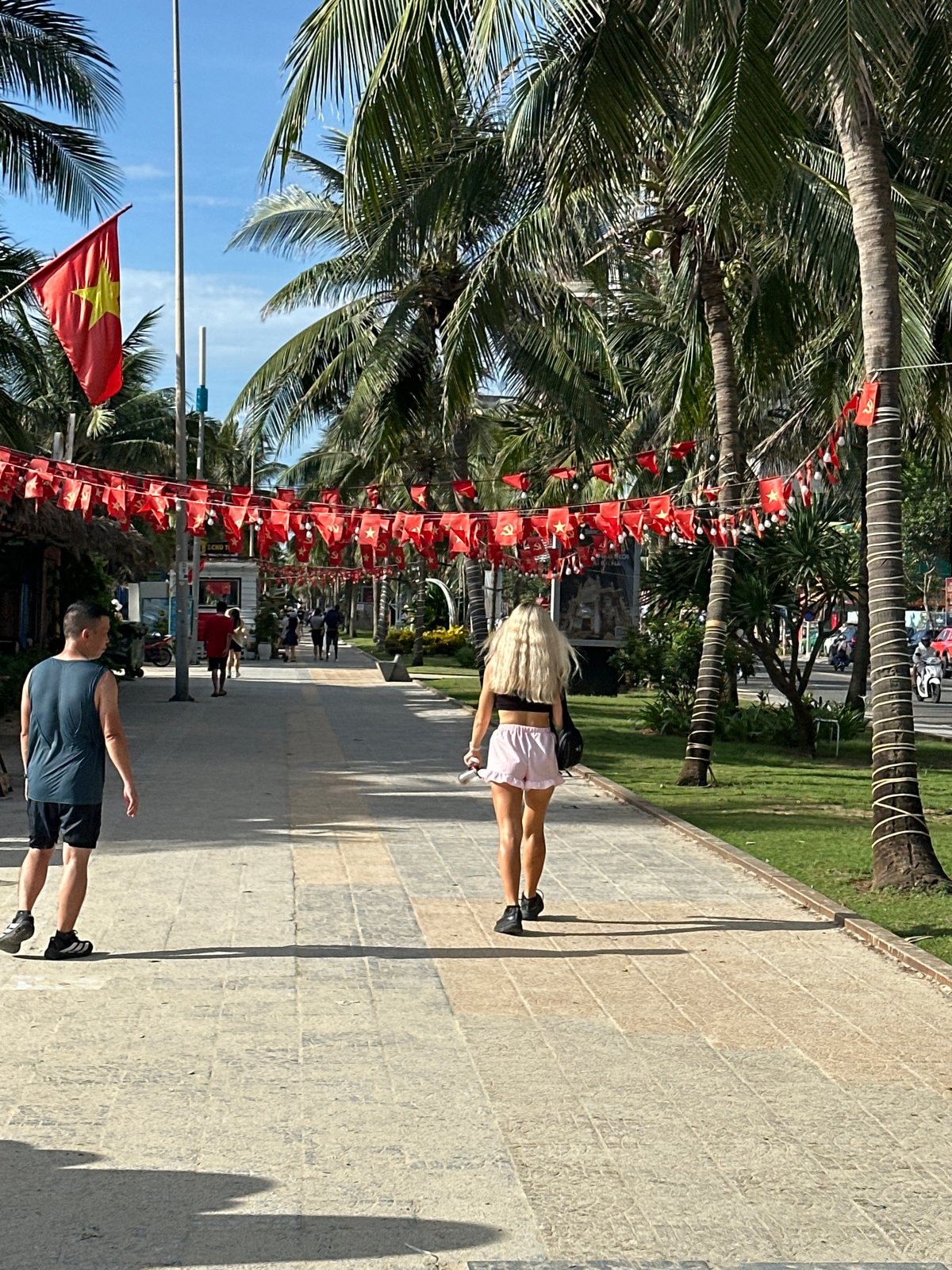 Morning activity on Đà Nẵng's flag-decorated beachfront promenade