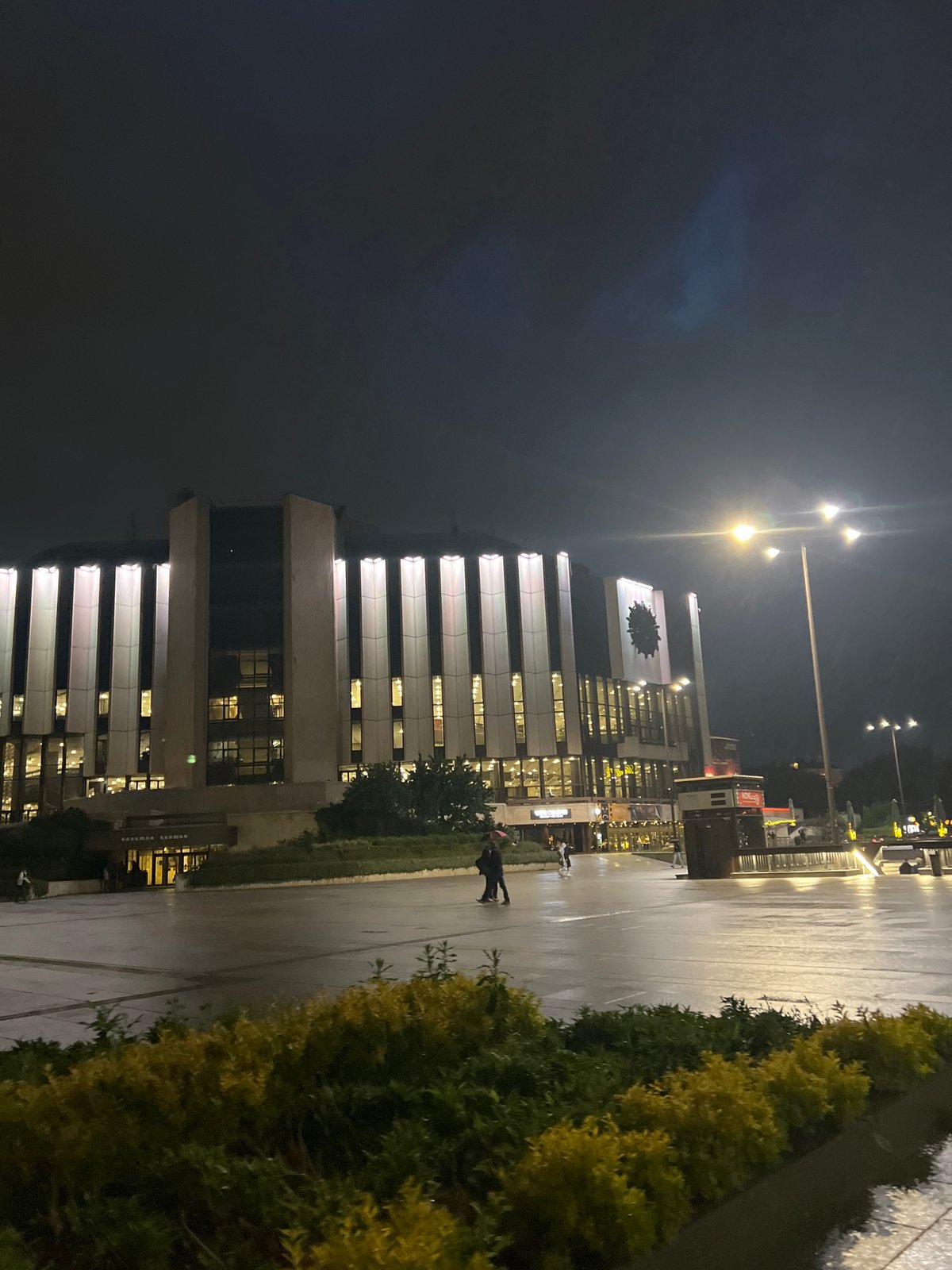 Modern building with clock documented in nighttime Sofia