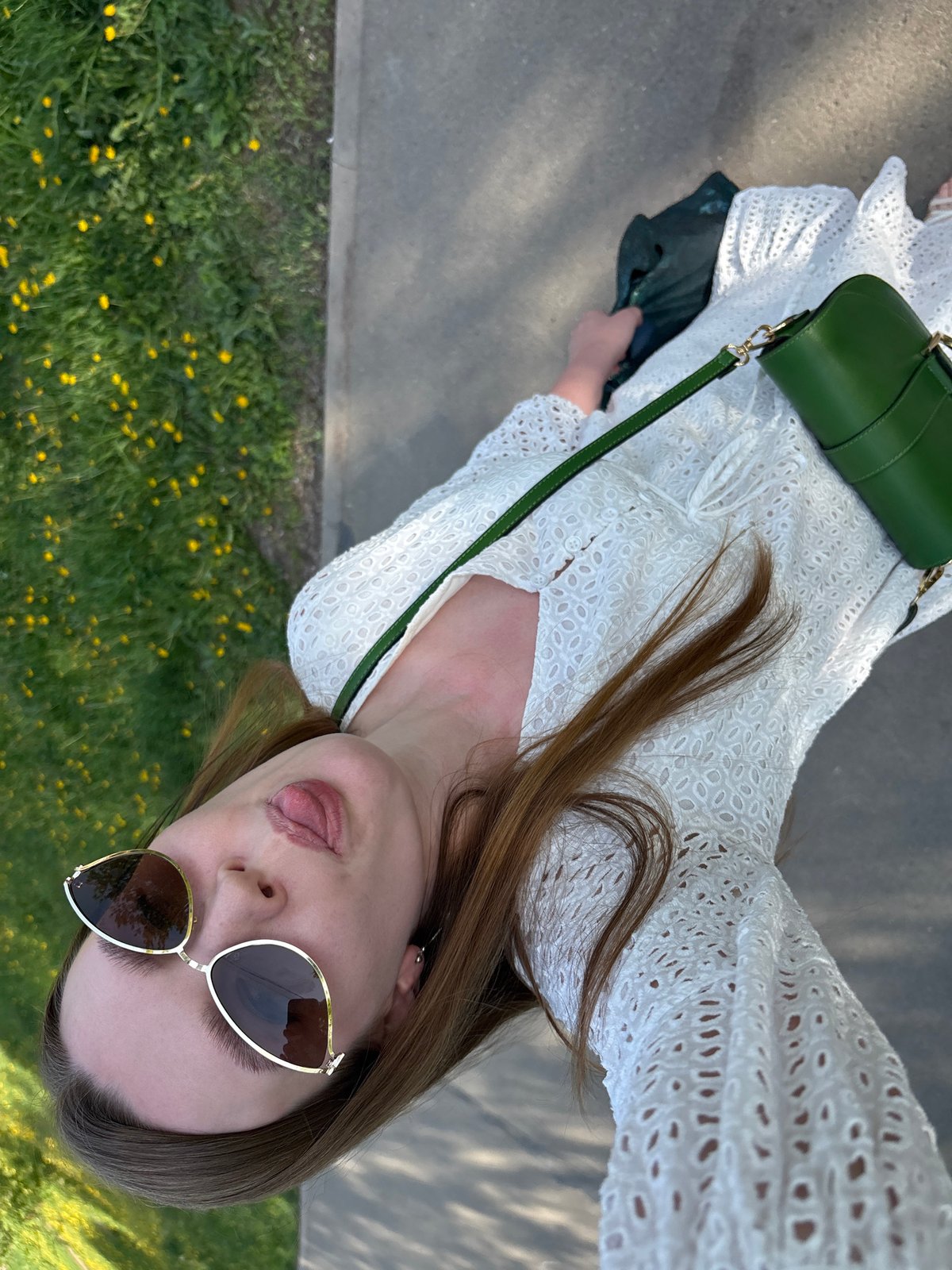 Woman poses playfully for photos on Izhevsk sidewalk
