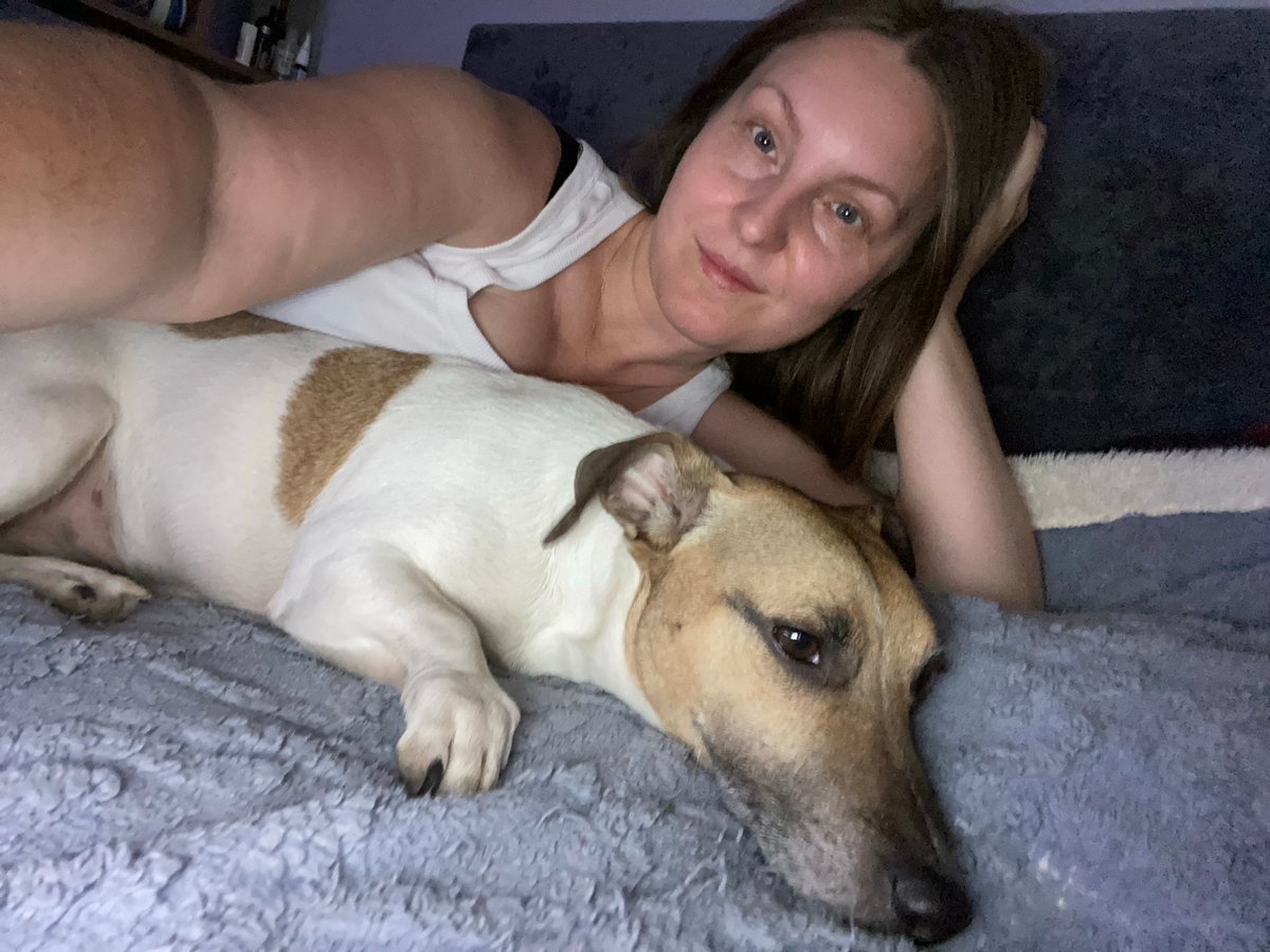 Woman and dog rest together on furniture in Noviy
