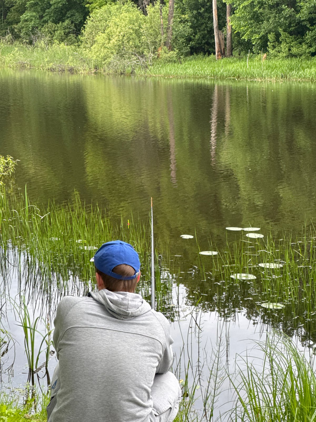 Man fishing at water's edge in Noviy, Russia