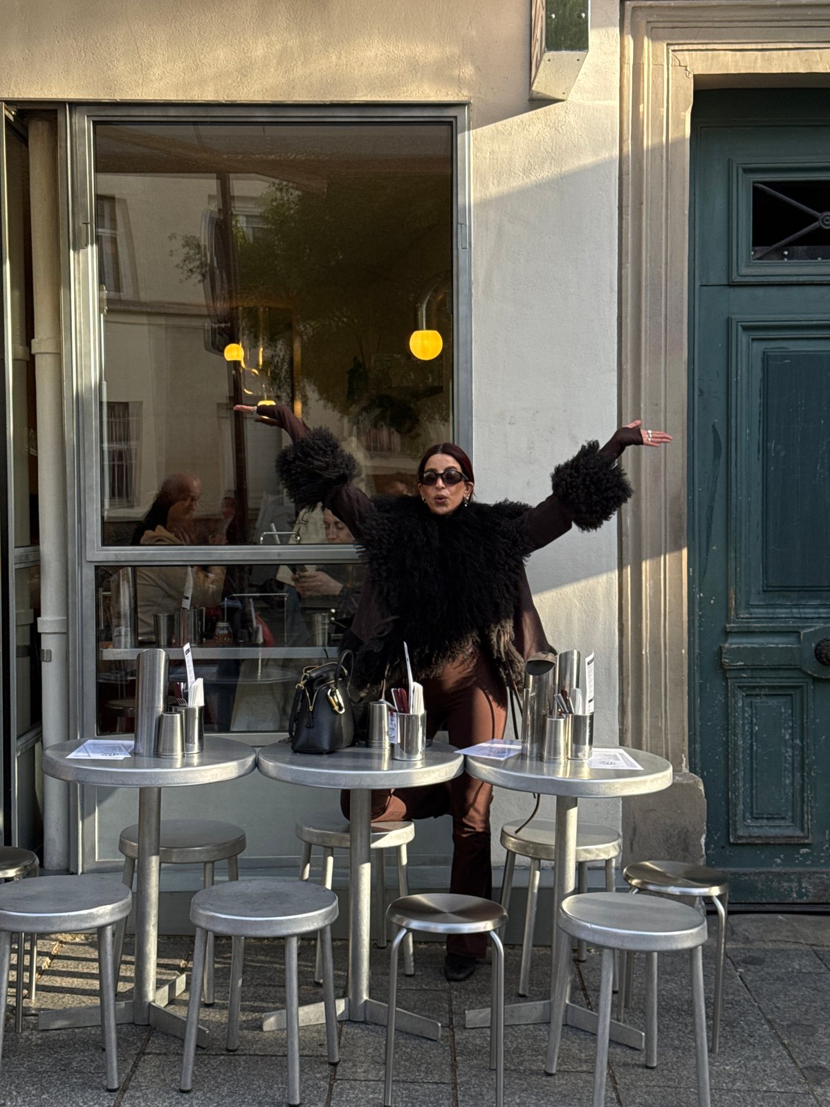 Woman poses outside Paris building in feathered jacket