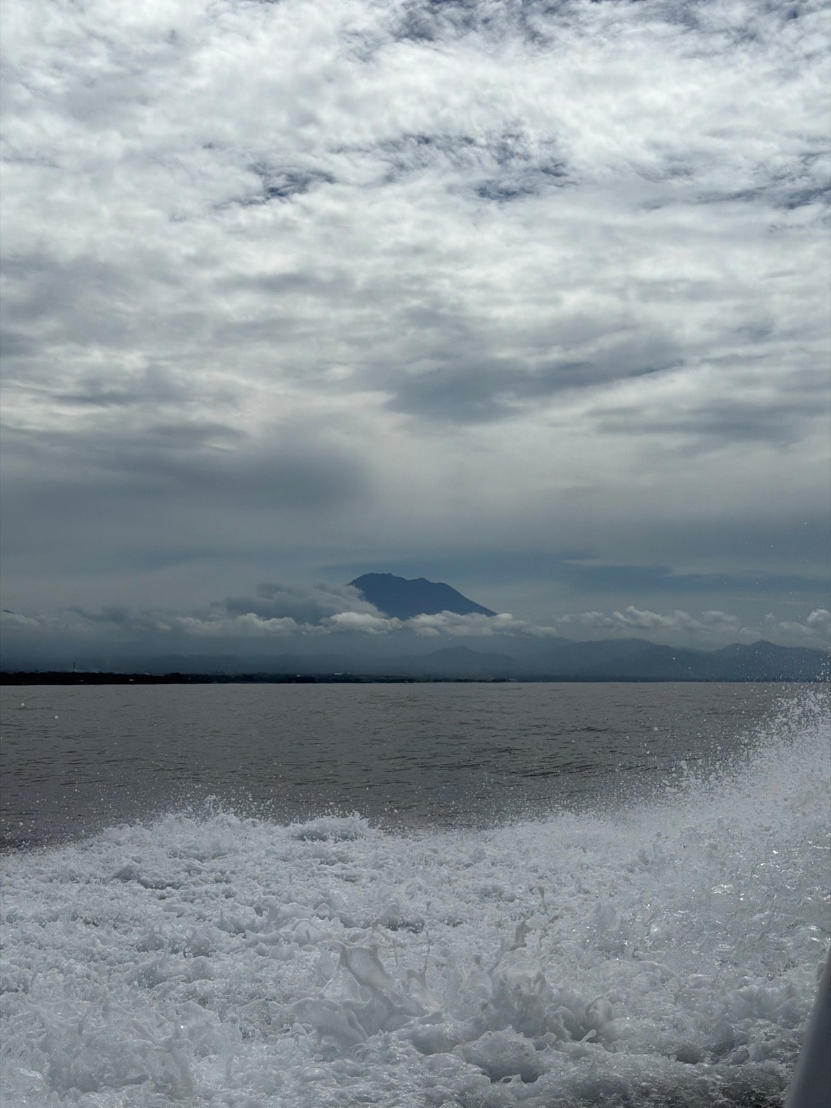 Mountain silhouette and waves captured in Indonesian landscape view