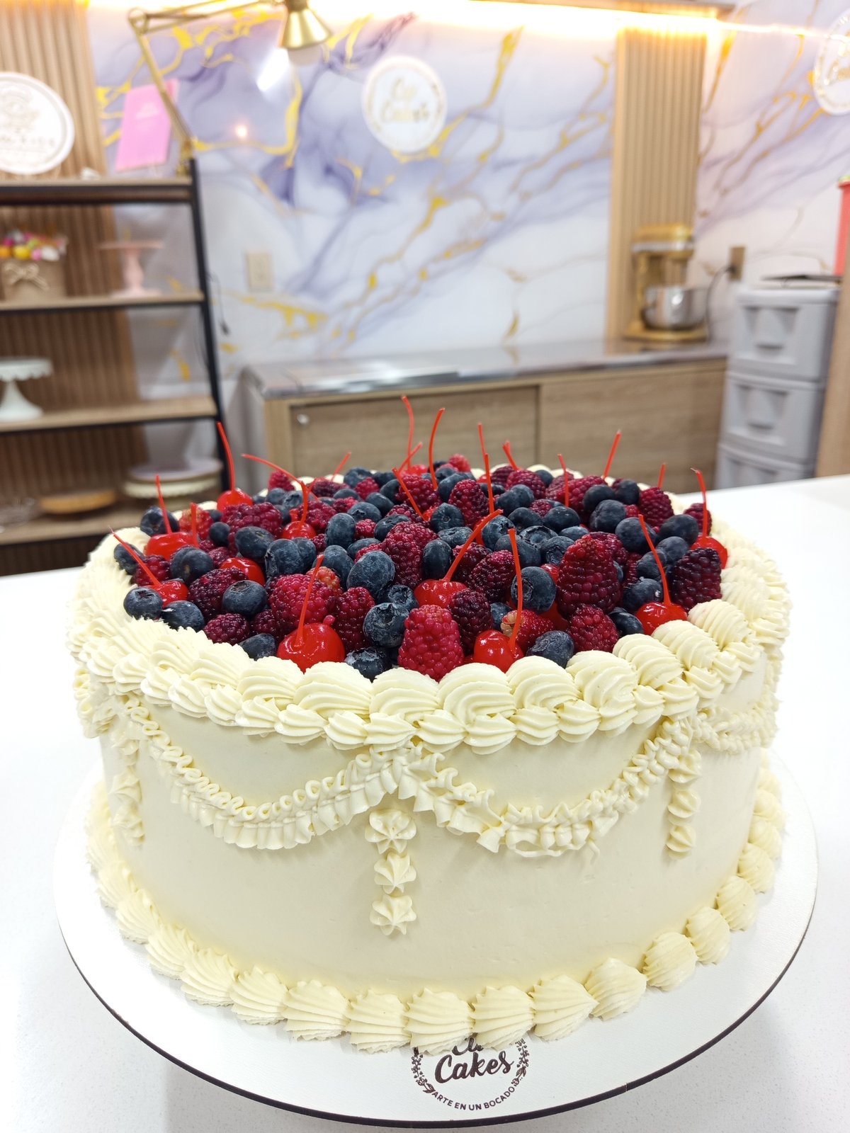 Frosted berry cake with intricate decoration in Girón