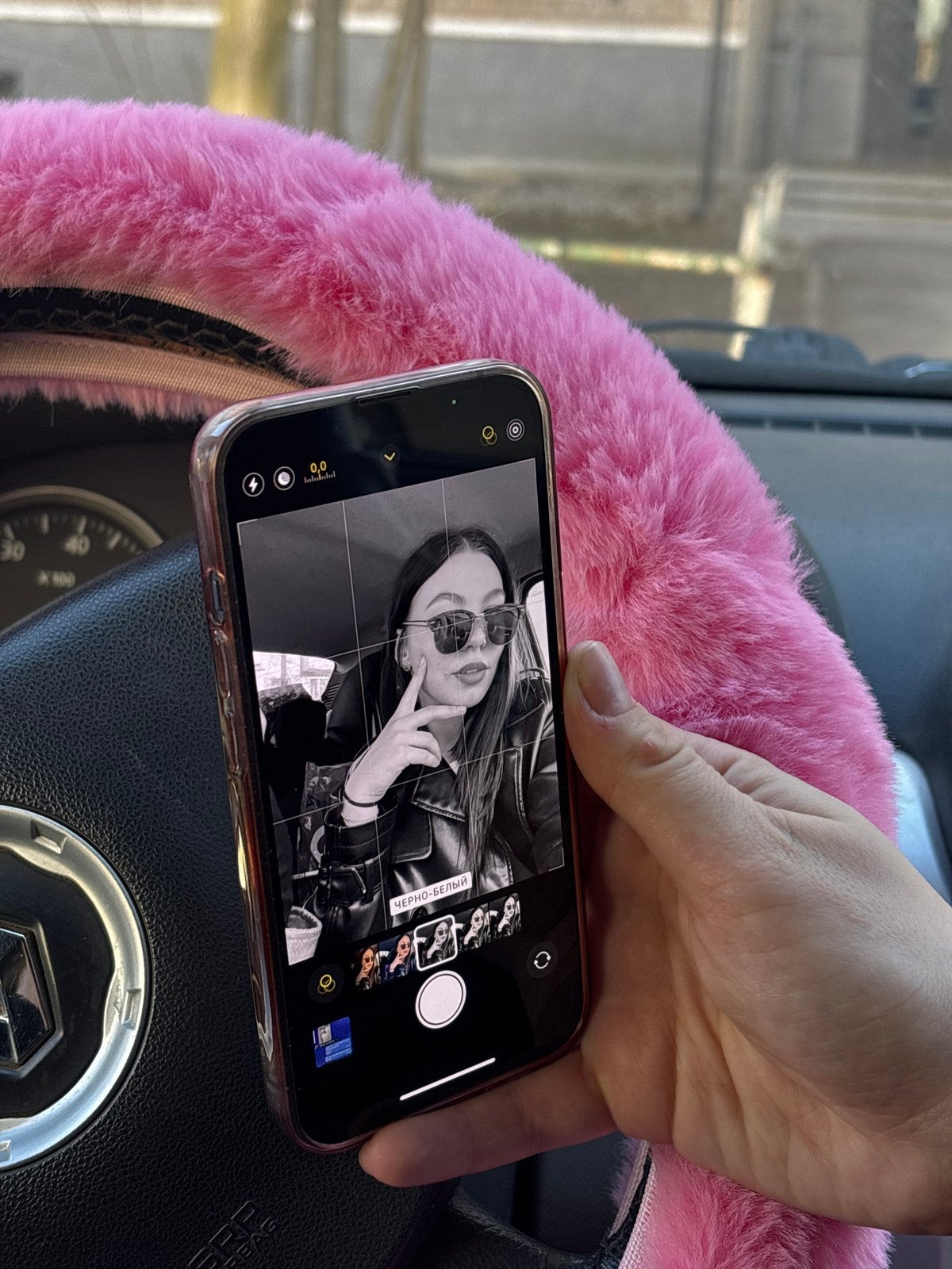 Driver views black-and-white photo on smartphone in Perm