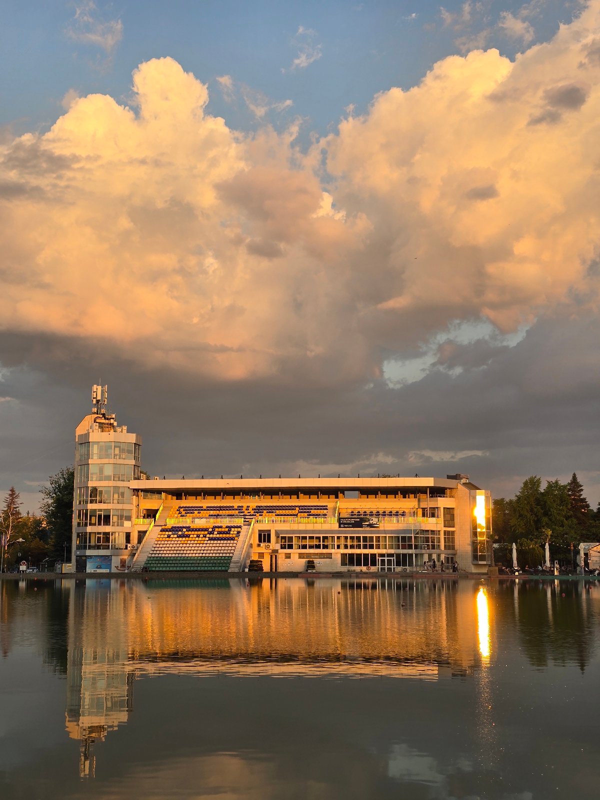Lakeside building reflections and fish schools observed during sunset
