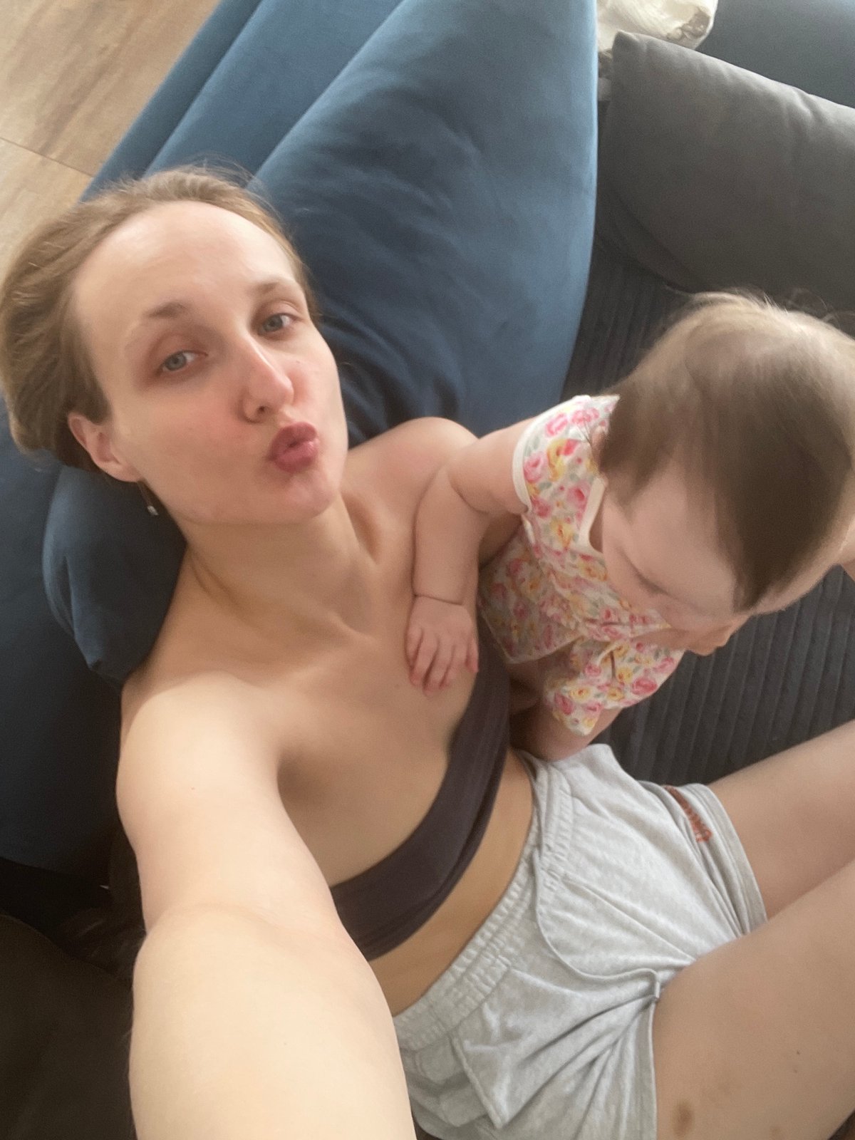 Mother and baby share tender moment on sofa in Podshivalovo
